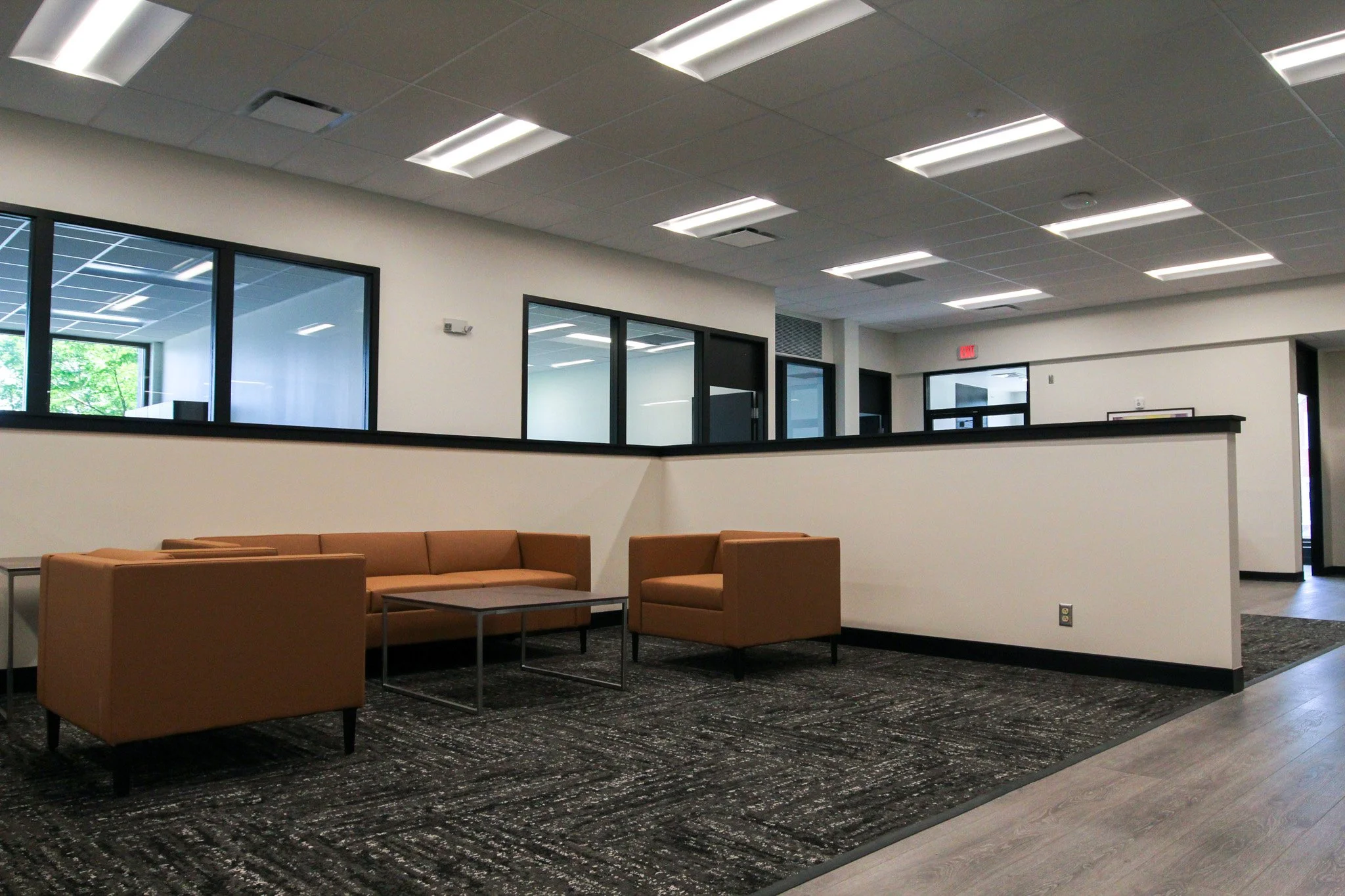 Empty indoor waiting area of Simmons Bank in Athens, TN with tan chairs, large windows, white walls, and a drop ceiling with fluorescent lights.