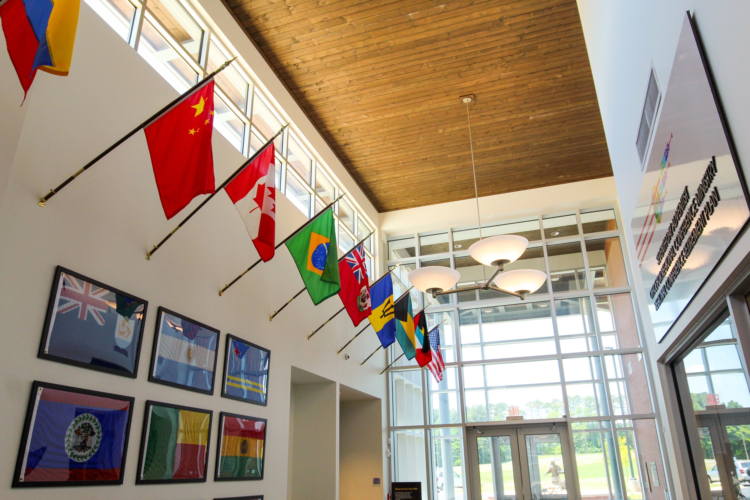 Indoor space with flags from different countries hanging from the ceiling, framed pictures on the wall, large windows, and a flat screen monitor. Design build by  P&C Construction, Inc. - Chattanooga, Tn.