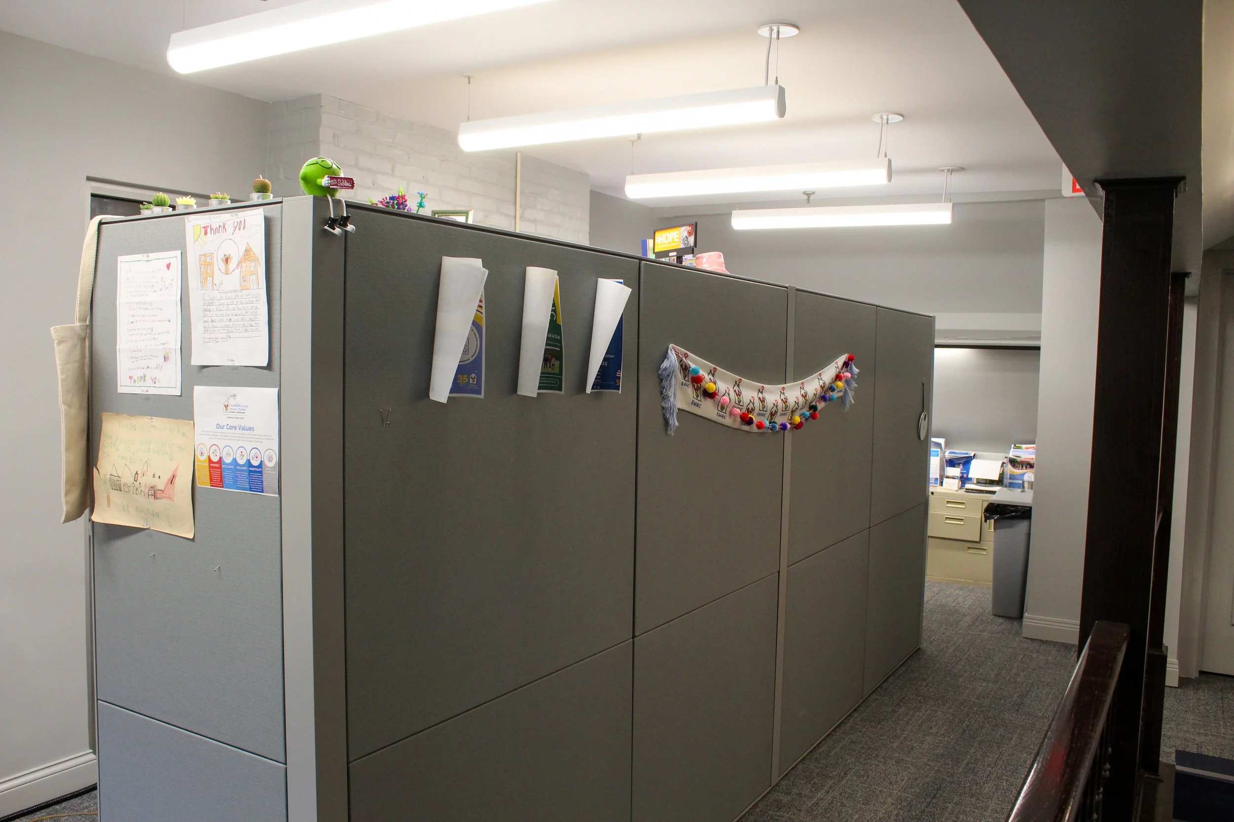 Office cubicles decorated with children's artwork and holiday decorations.