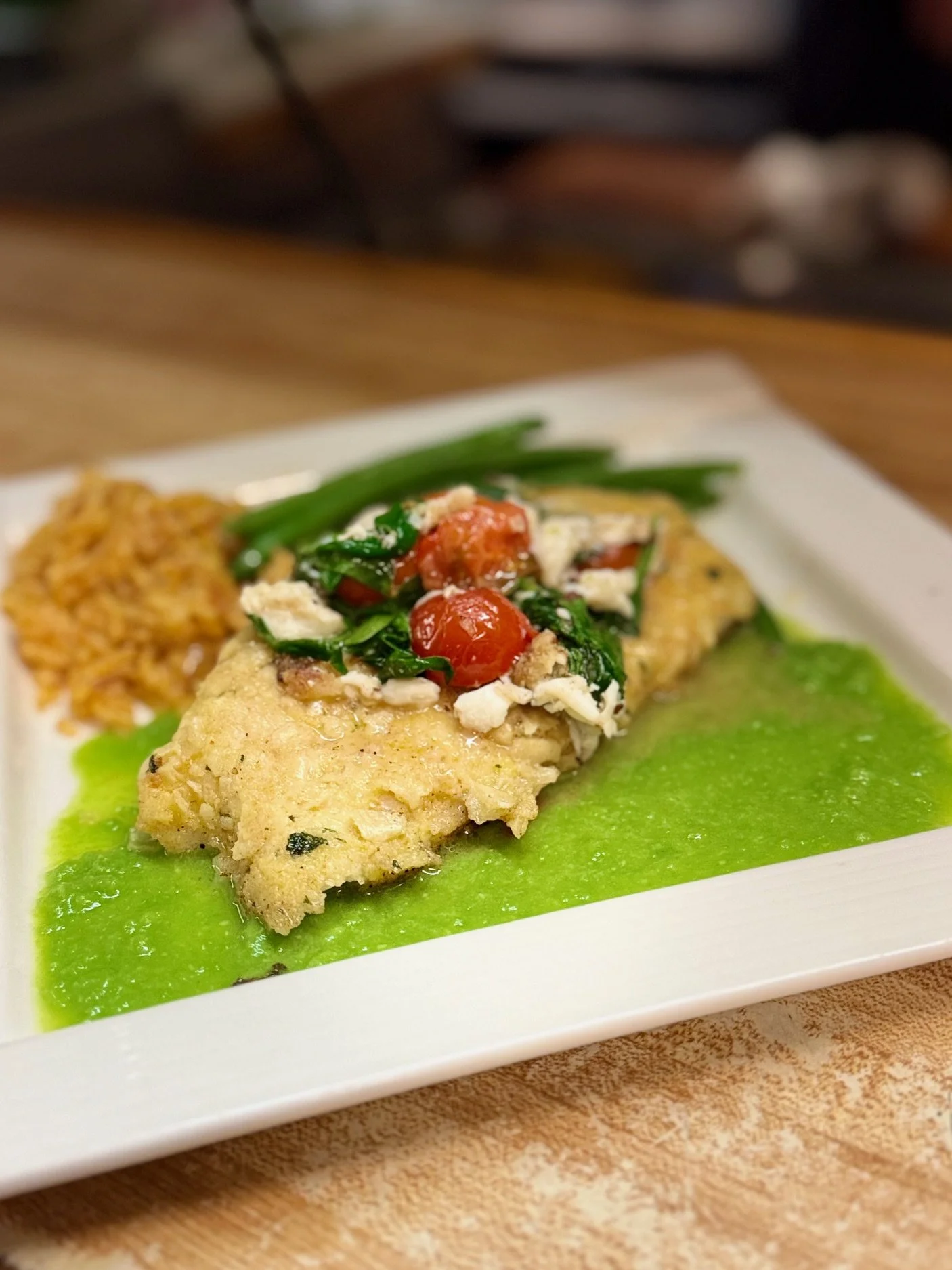 Cornmeal encrusted sea bass with tomatoes, spinach. crab meat
