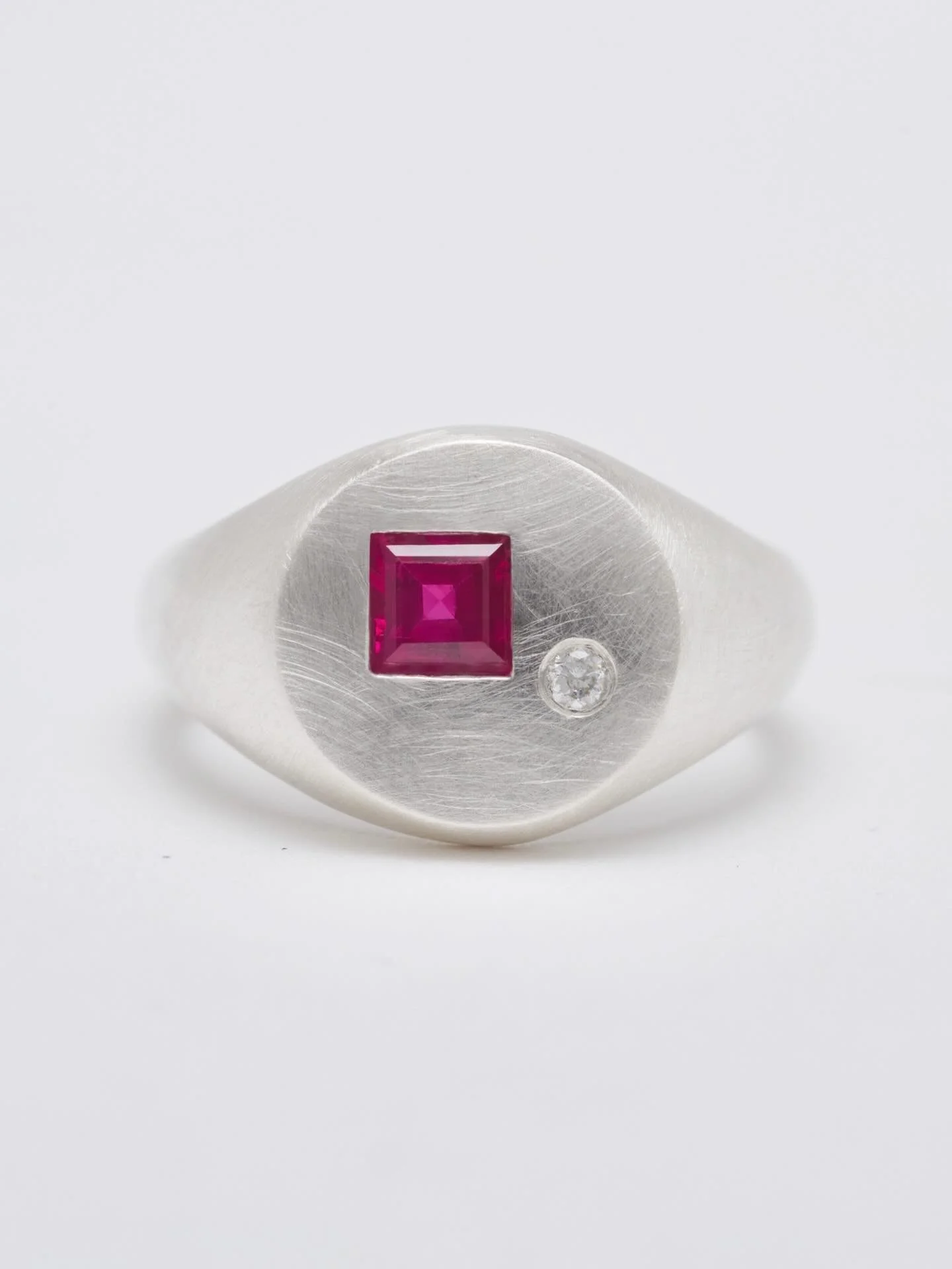 Ruby Sol, this one glows.
Featuring a square 4mm ruby and a 0.03 ct diamond. Hand carved in wax and cast in brushed silver.
Sold