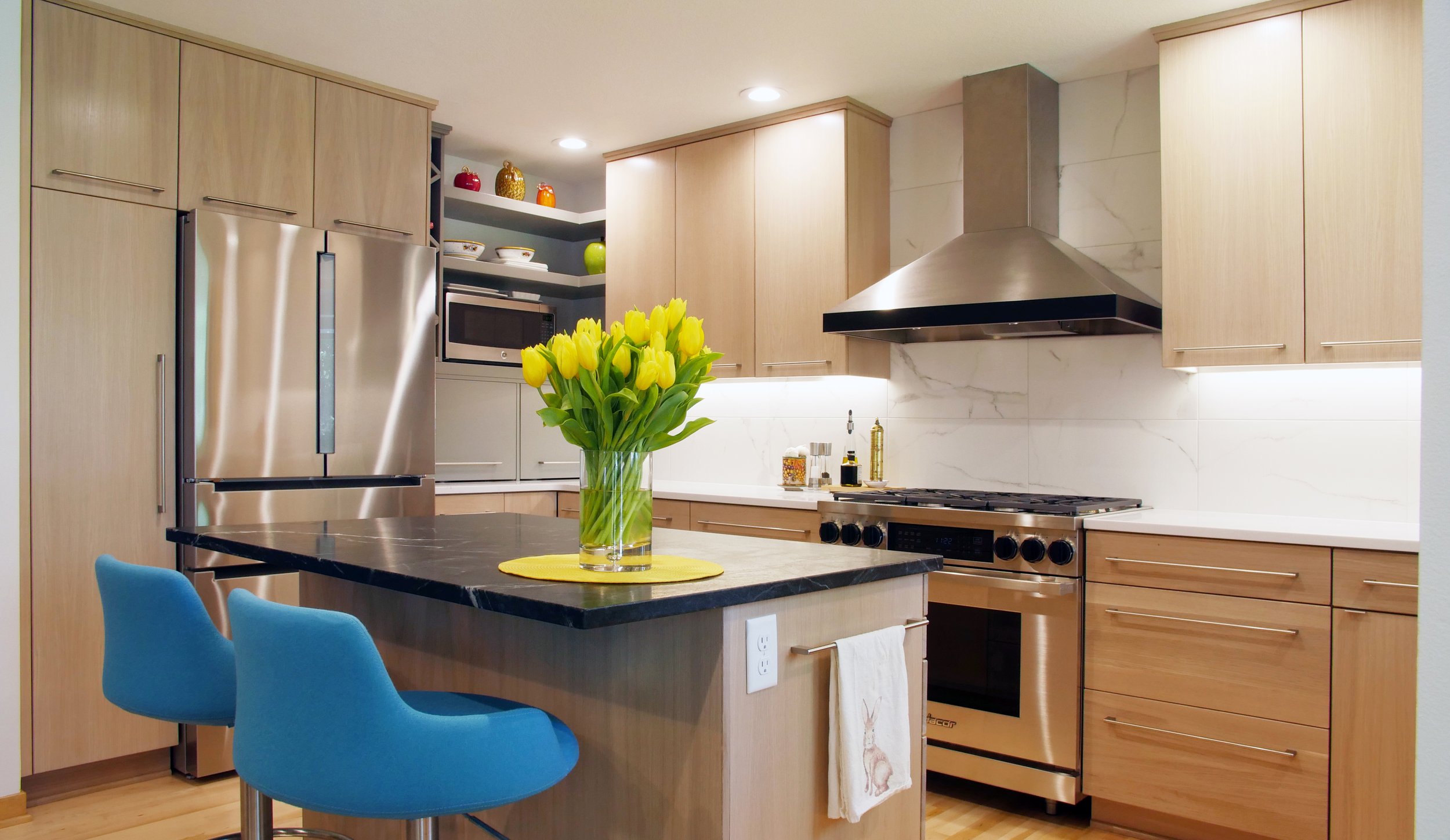 Modern white oak kitchen with slab doors sleek with a painted custom shelfs and storage areas. This kitchen features many of the customizable options such as a drawer with a spice rack, pots and pans storage and utensil dividers.