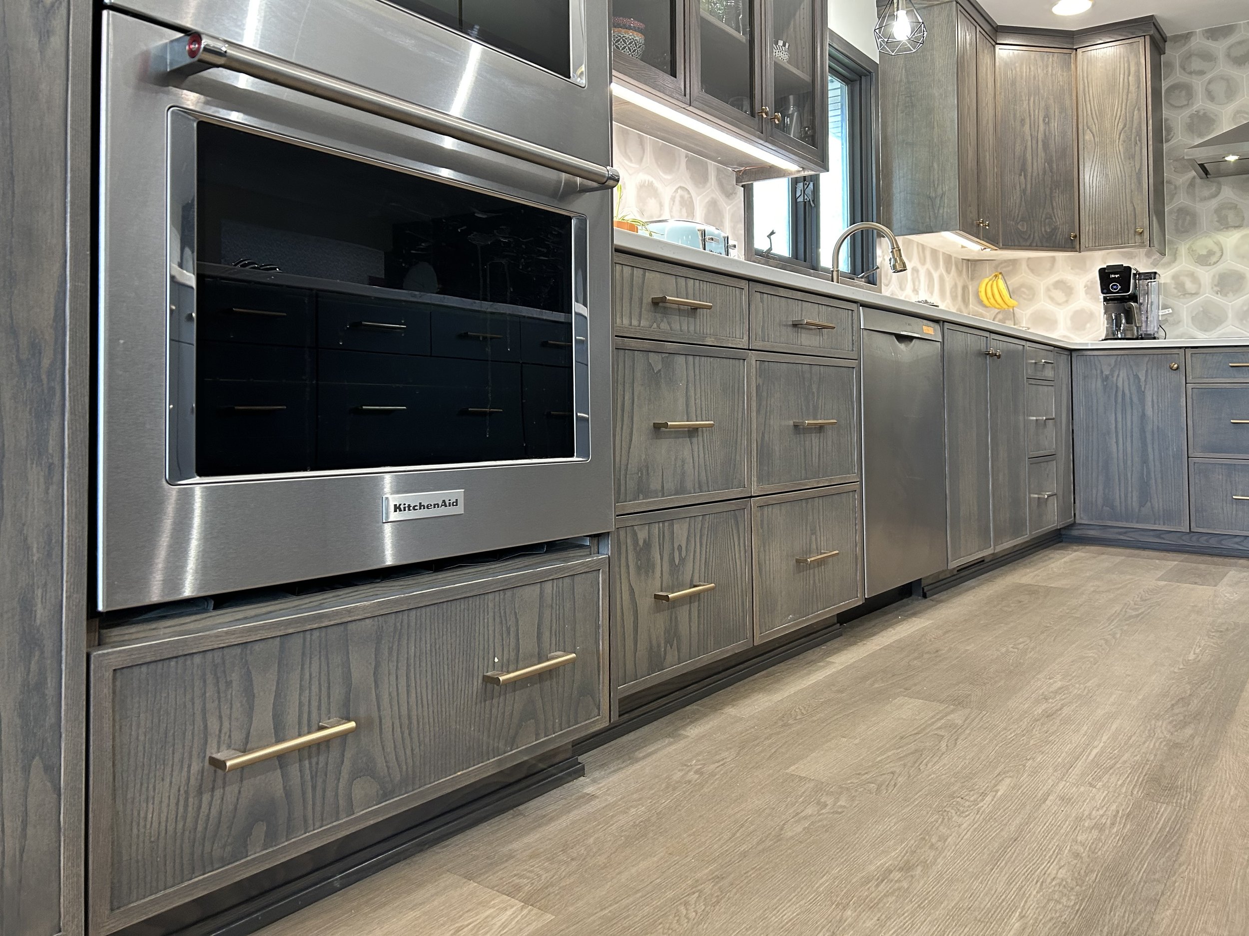 Introducing our first skinny shaker door kitchen! 🤩 ✨ This is a scandinavian kitchen with ash wood in a warm grey stain. 🍽️ The island cabinet surfaces are a charcoal melamine and will be really durable! We finished the look with champagne bronze k