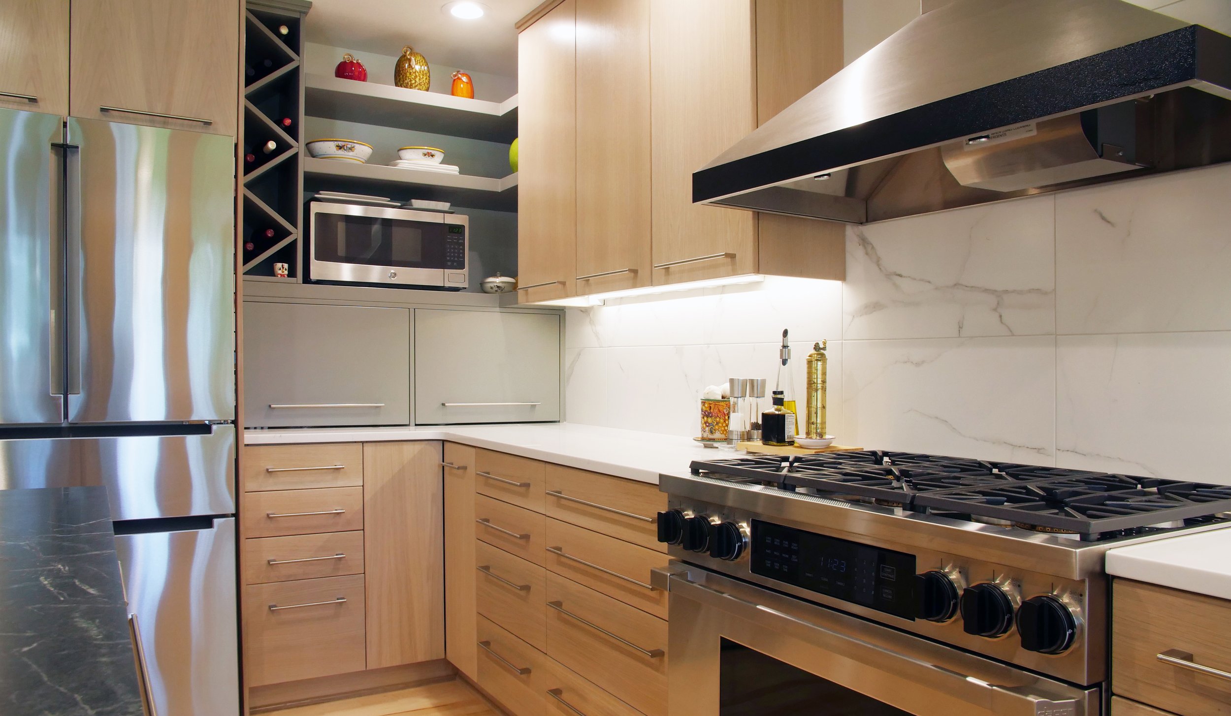 Modern white oak kitchen with slab doors sleek with a painted custom shelfs and storage areas. This kitchen features many of the customizable options such as a drawer with a spice rack, pots and pans storage and utensil dividers.