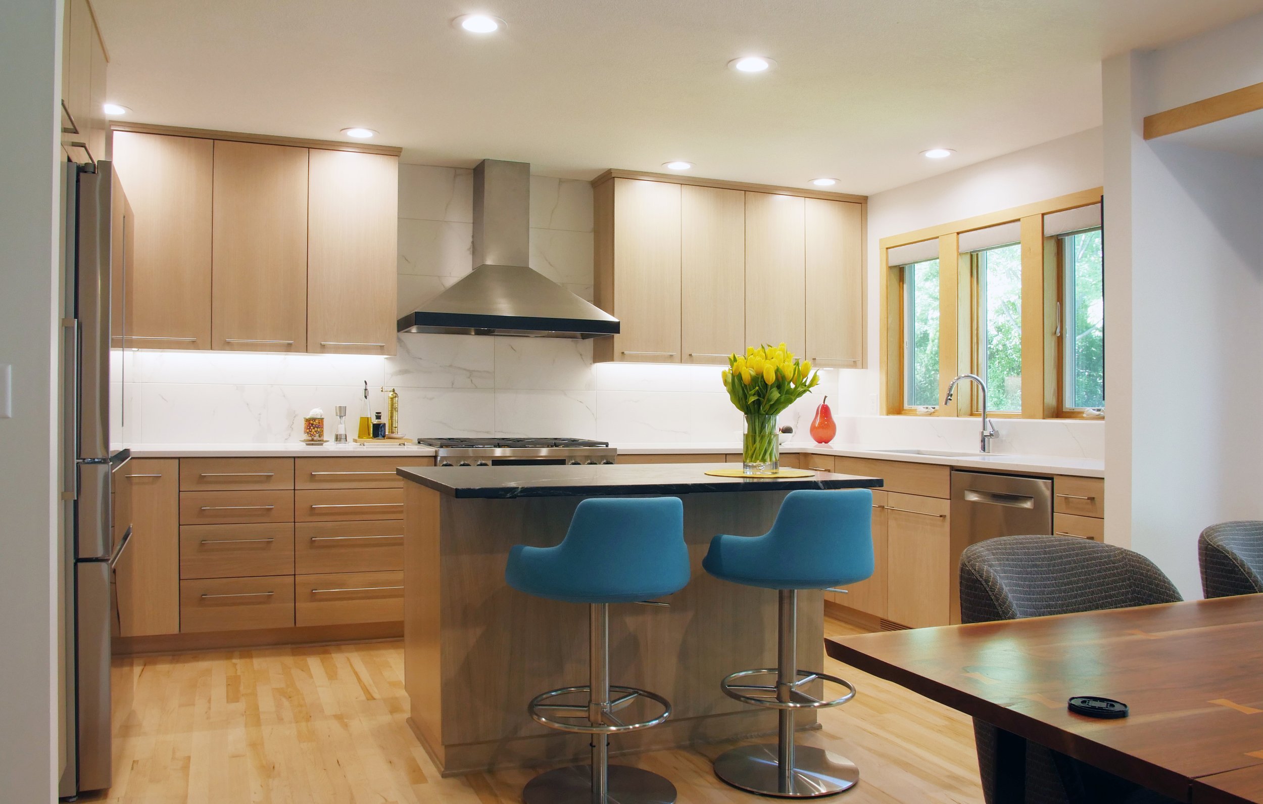 Modern white oak kitchen with slab doors sleek with a painted custom shelfs and storage areas. This kitchen features many of the customizable options such as a drawer with a spice rack, pots and pans storage and utensil dividers.