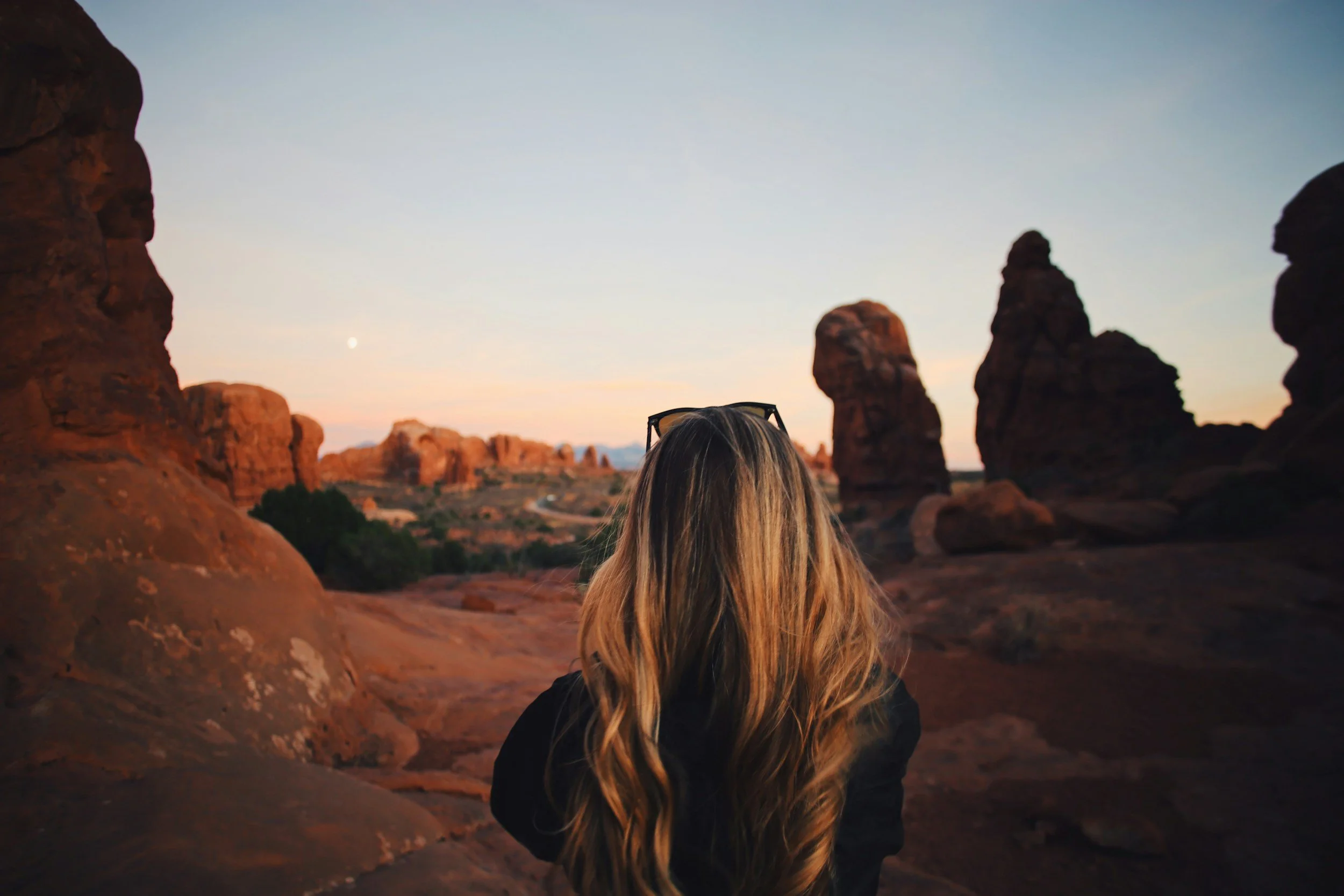 Woman with long Utah curls hairstyle overlooking a Utah desert landscape, representing beauty standards, perfectionism, and identity in Mormon culture.