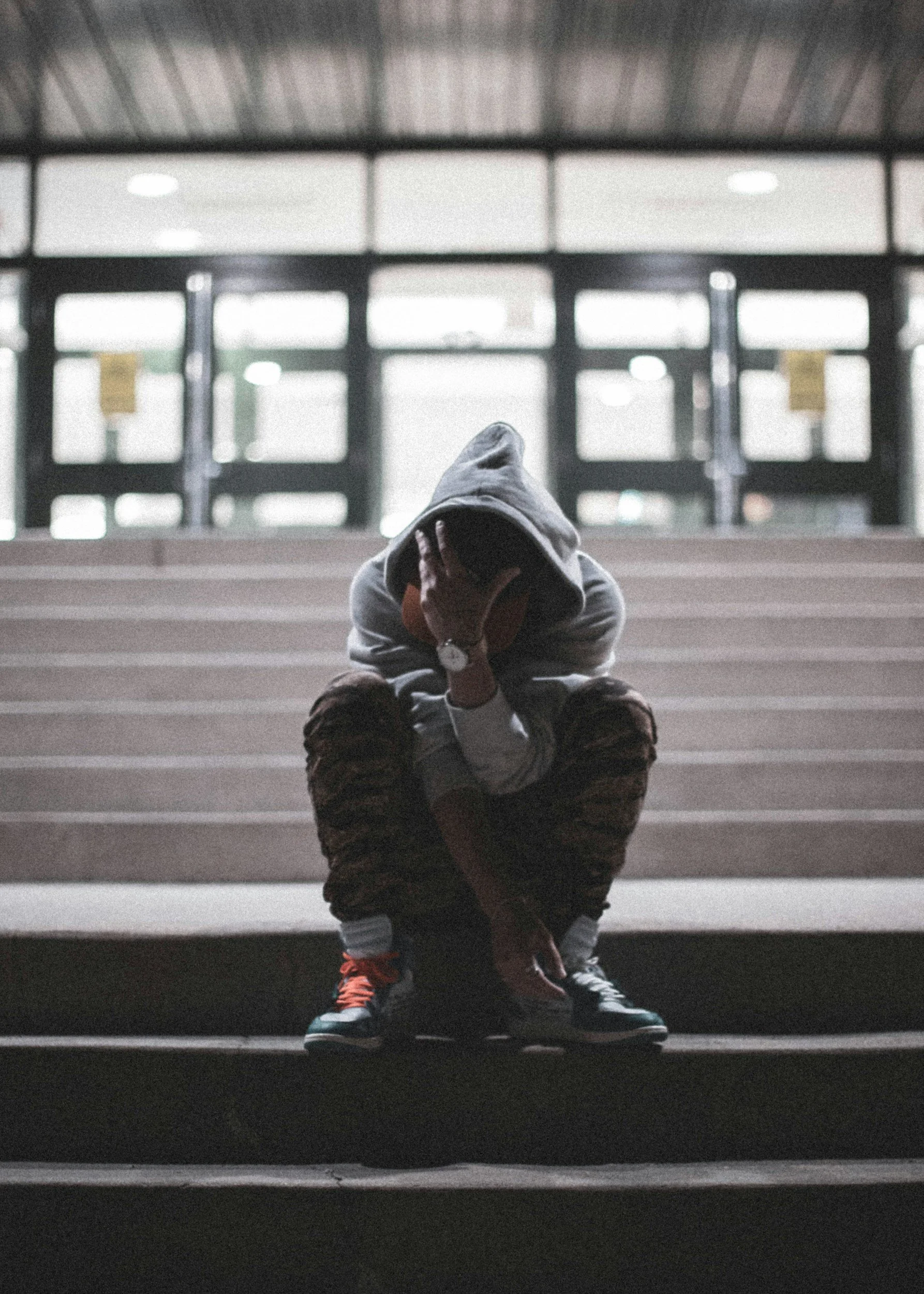 Teen sitting alone and struggling emotionally, representing the importance of family support for LGBTQ+ youth