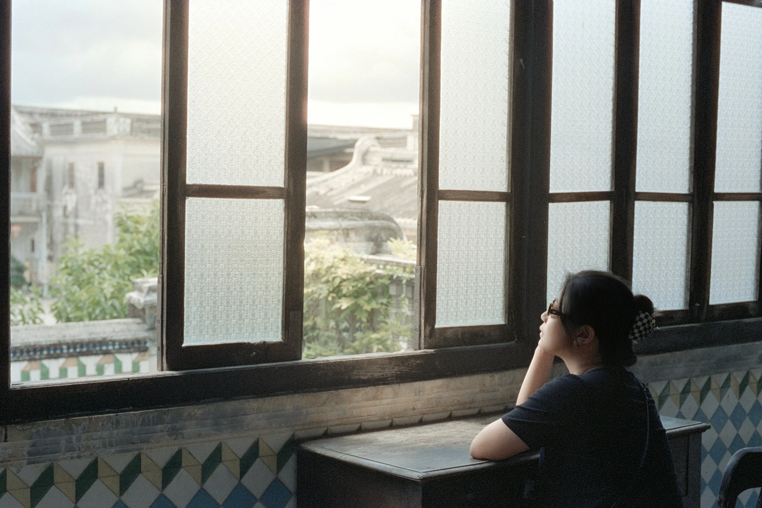 Person sitting by a window reflecting on personal identity, self-discovery, and what feels most authentic to them.