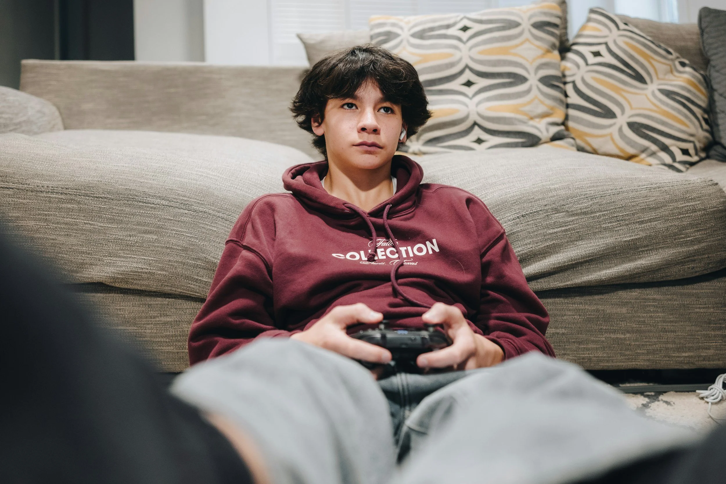 Teen spending time alone playing video games, representing the emotional withdrawal and overthinking some adolescents experience during summer break.