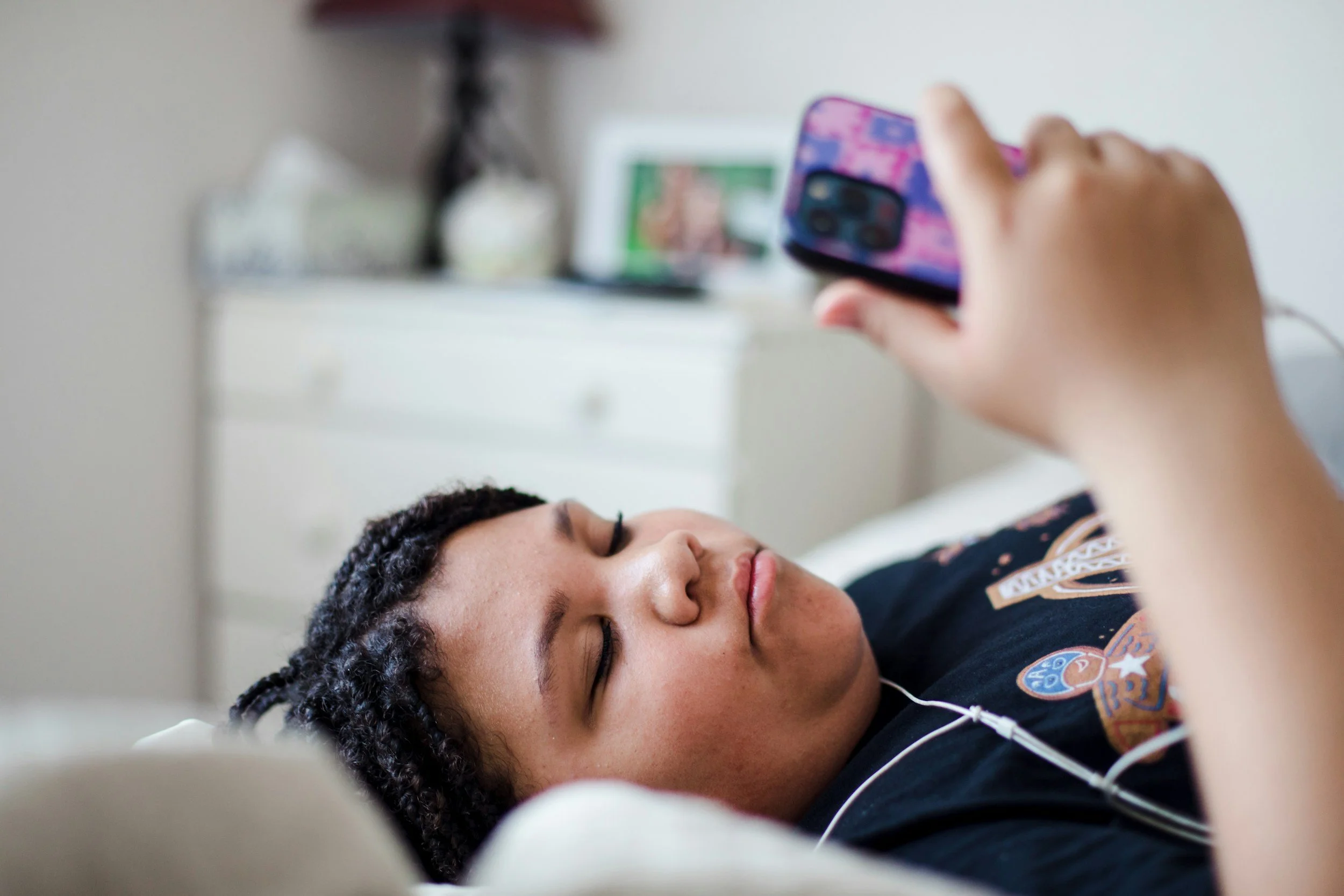 Teen scrolling social media during summer break, representing how online comparison can contribute to anxiety, loneliness, and low self-esteem.