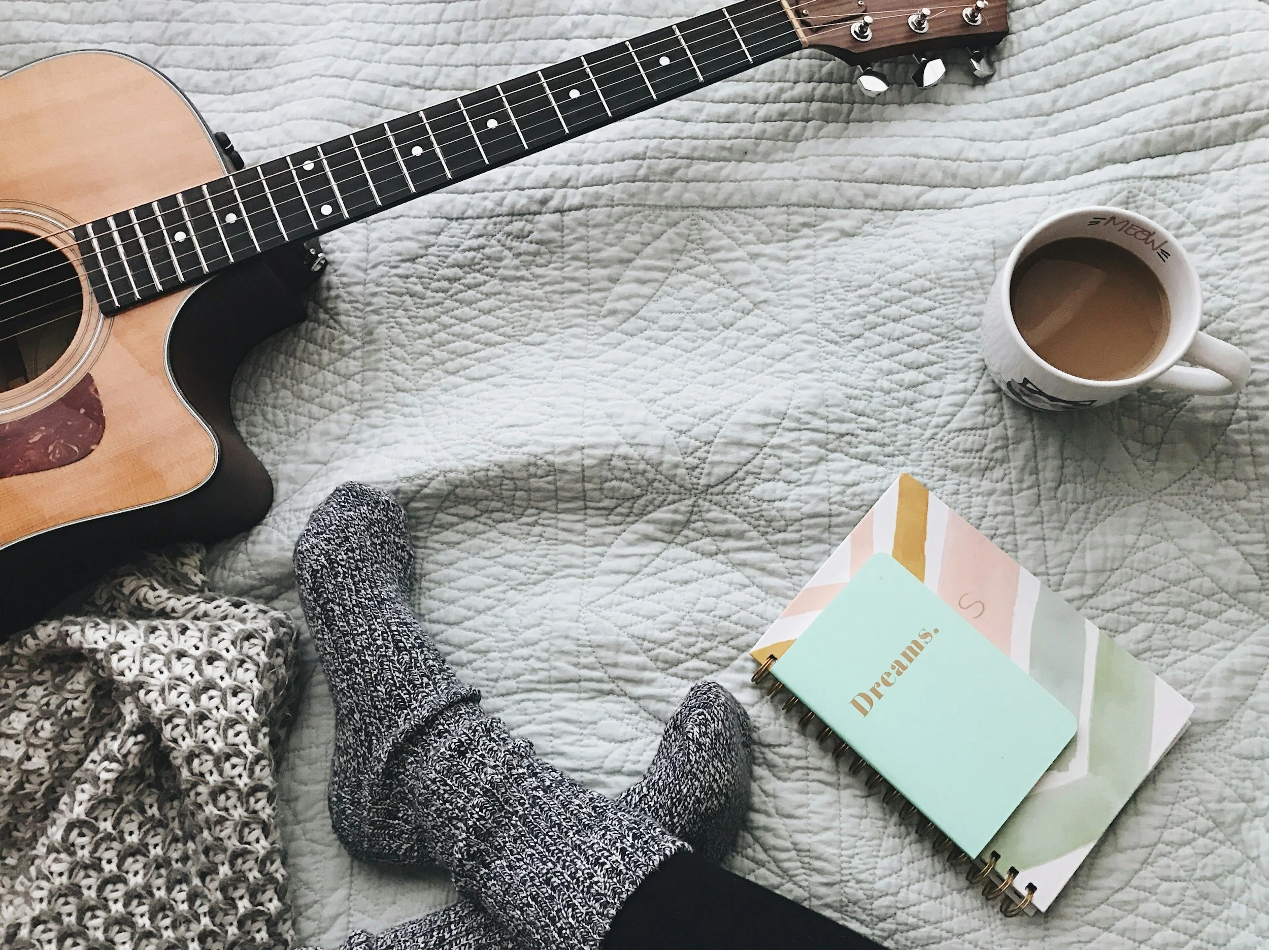 Journal, blanket, guitar, and tea representing an emotion regulation menu with self-care activities for managing difficult emotions.