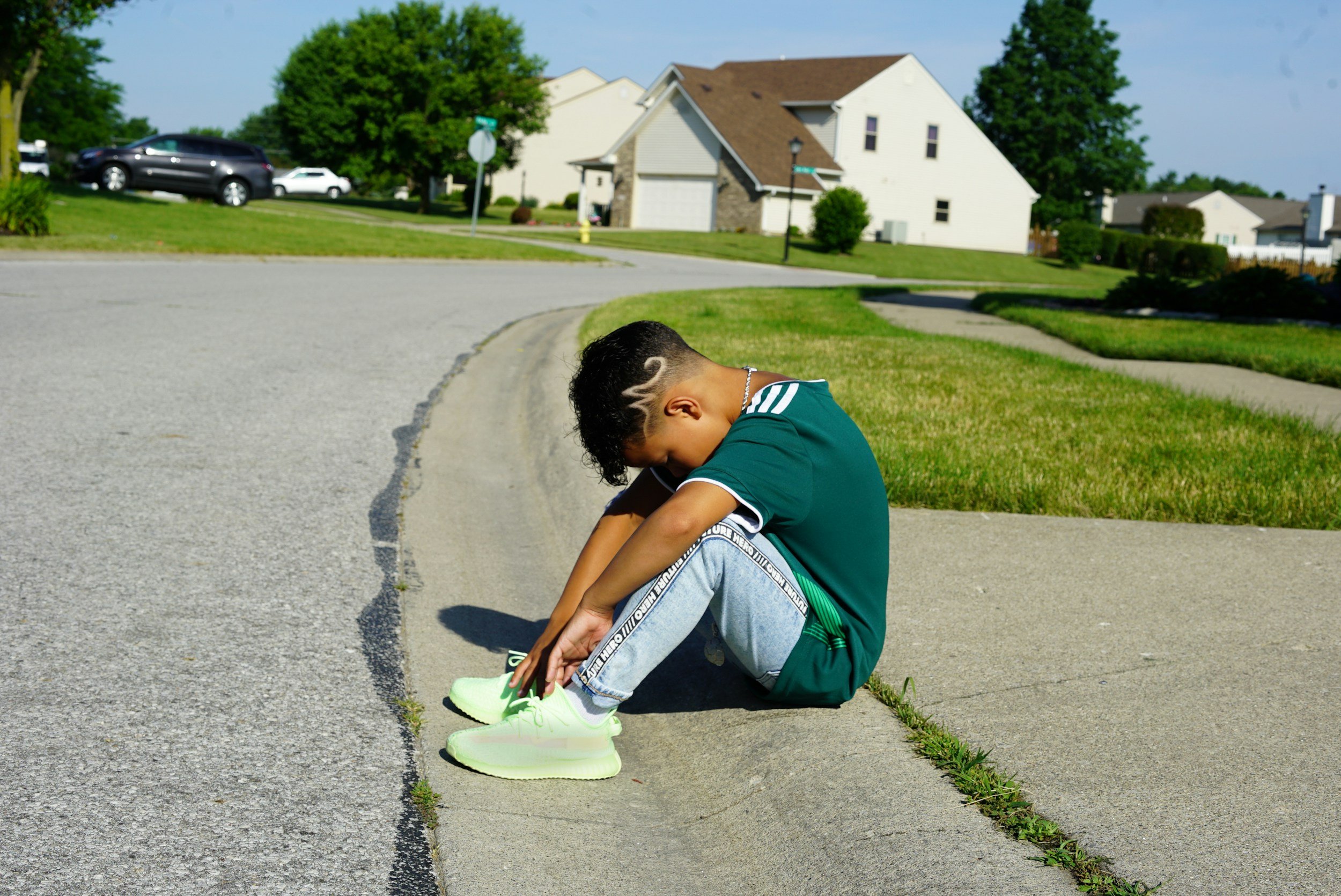 Child sitting quietly on a curb, illustrating the questions parents have about child behavior, emotional development, and whether their child is OK.