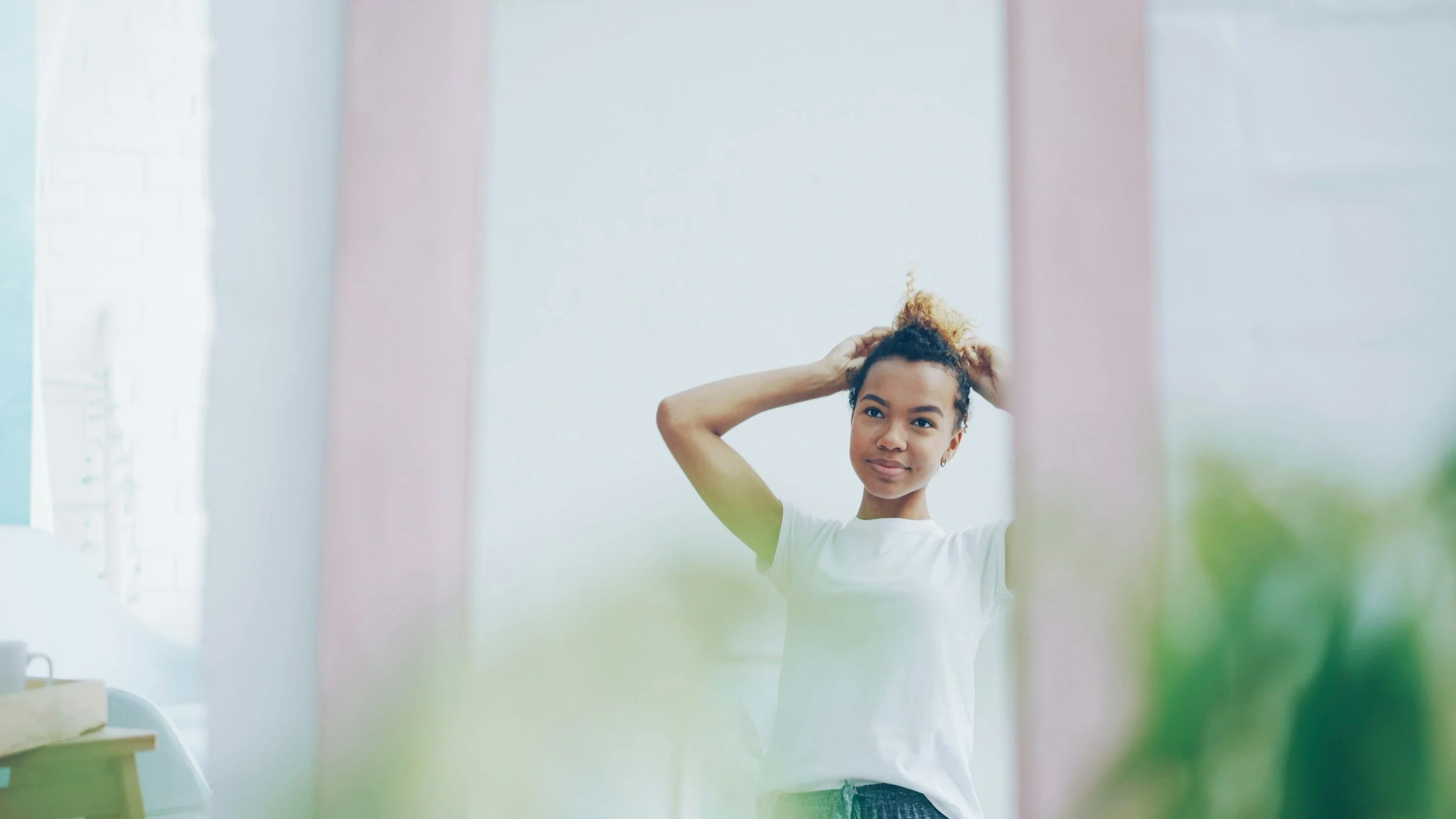 A woman looking at herself in a mirror, representing self-reflection, letting go of old family roles, and choosing to show up as your authentic self in family relationships.