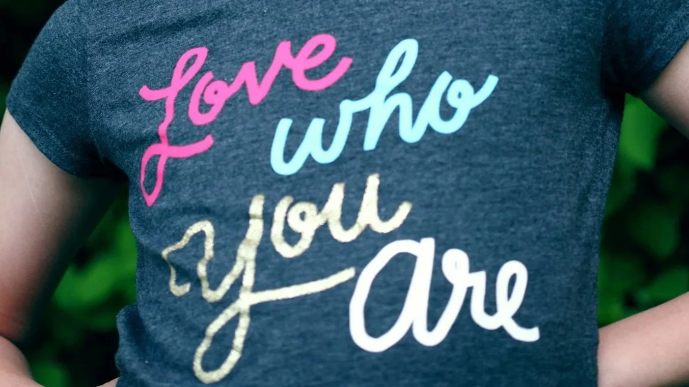 Shirt displaying the message “Love Who You Are,” representing acceptance and affirmation for LGBTQ+ youth