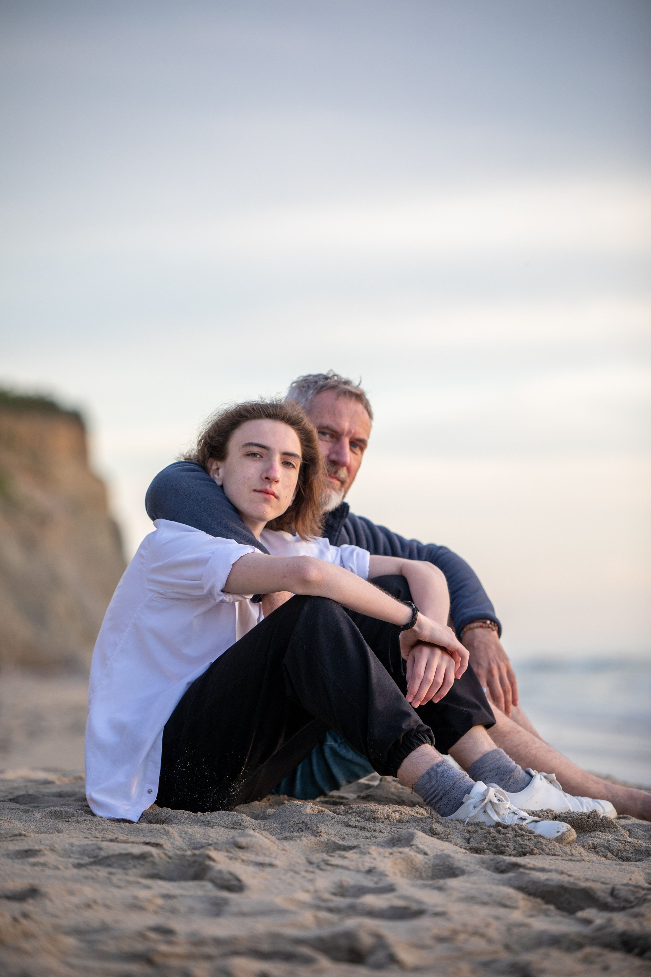 Parent sitting with their teenager outdoors, illustrating connection, support, and healthy communication during adolescence.