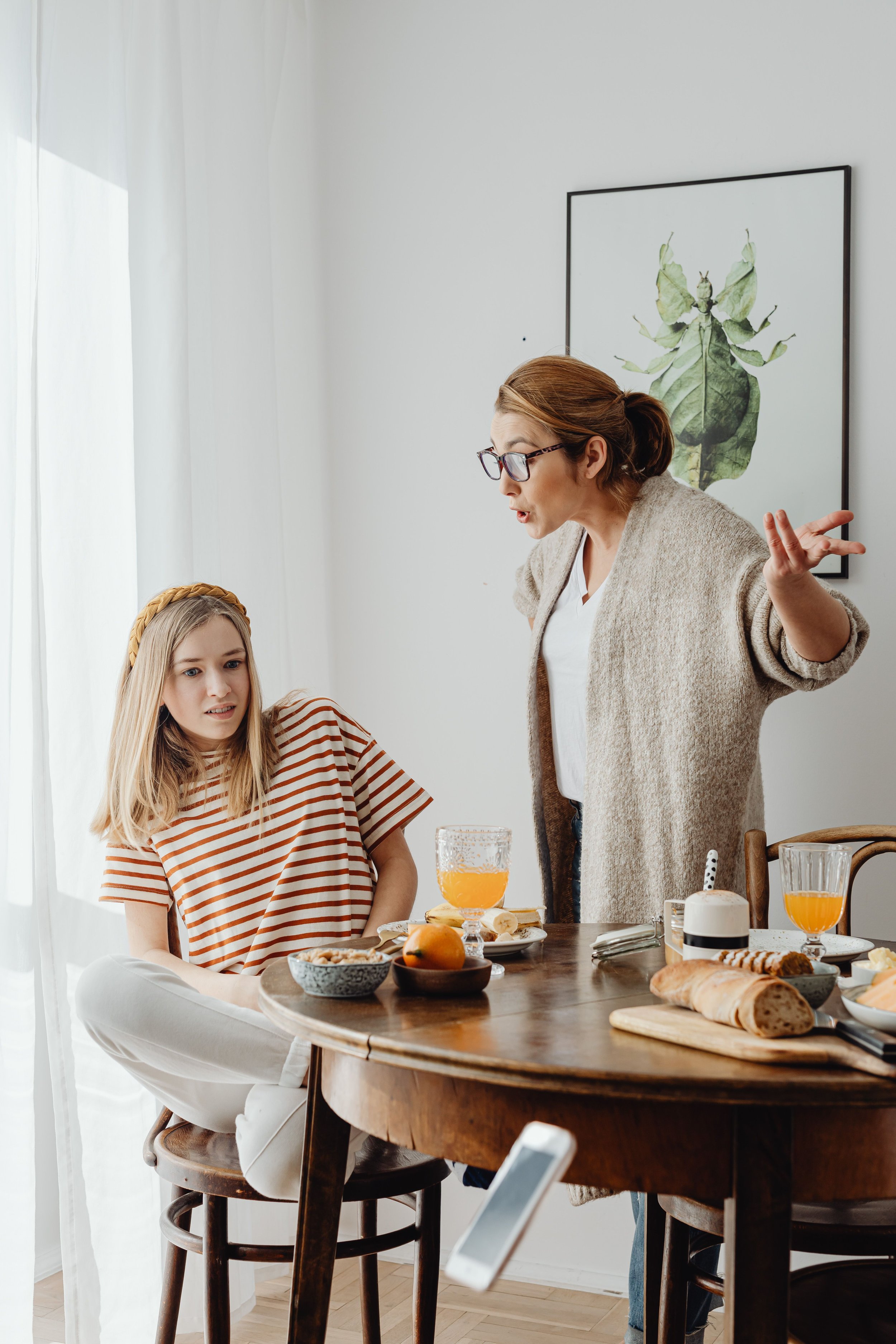 Parent and teenage daughter having a tense conversation, illustrating the family conflict and communication challenges that can increase during summer break.