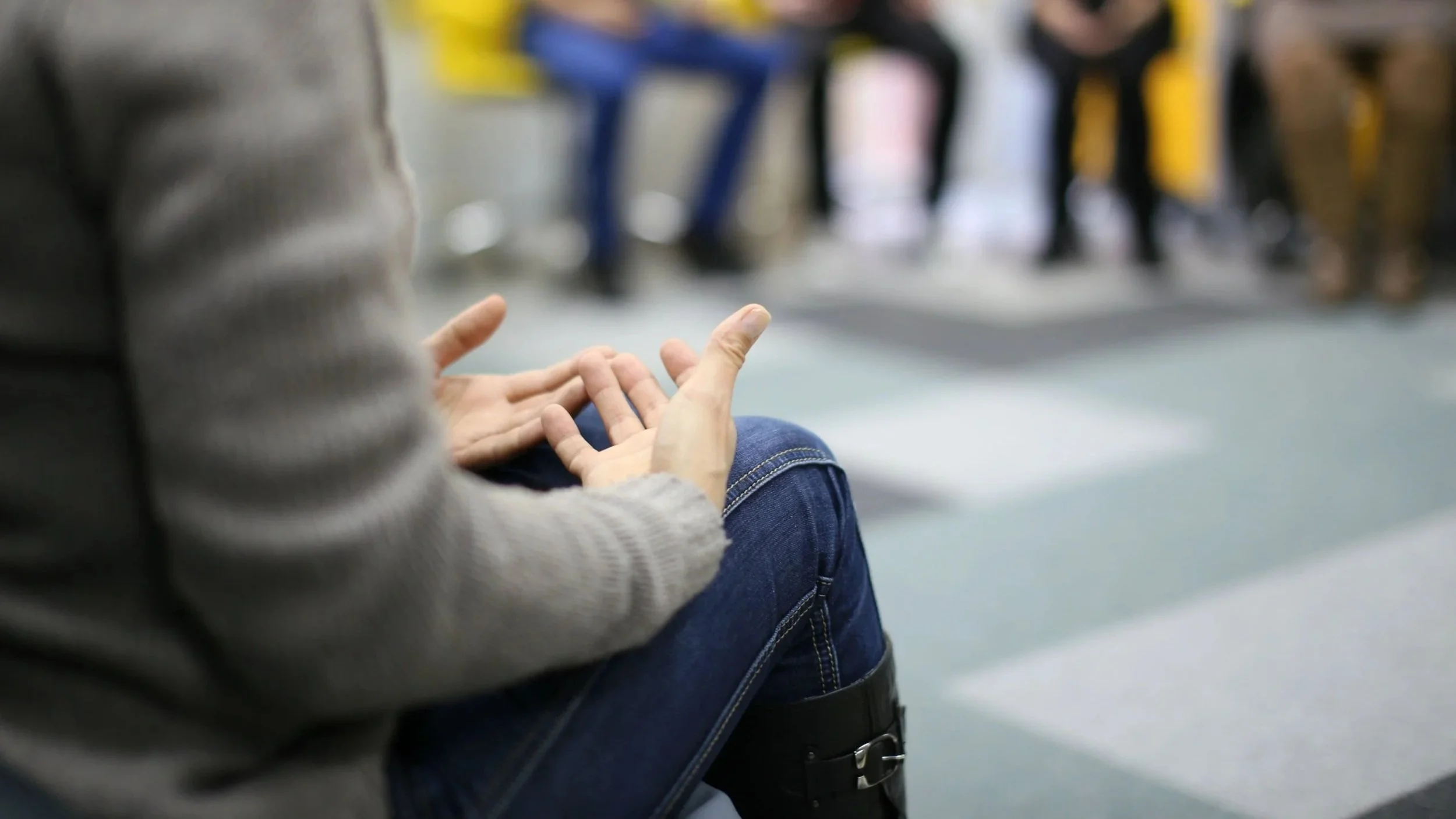 Close up image of two hands, palm up, resting on a person's lap.