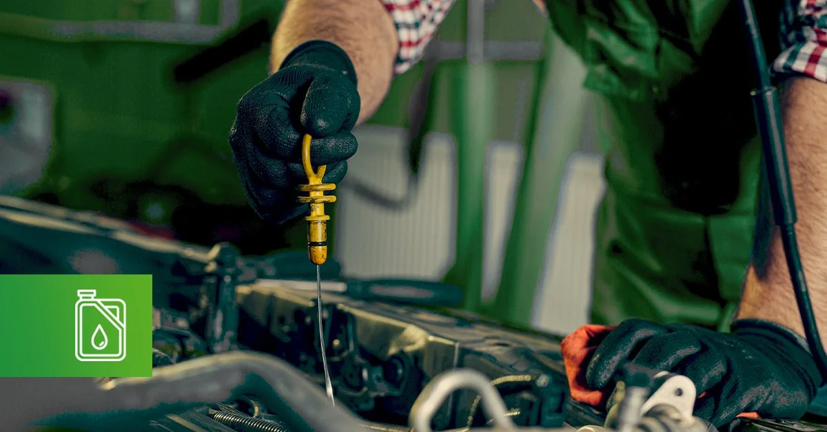 Auto mechanic checking car engine oil.