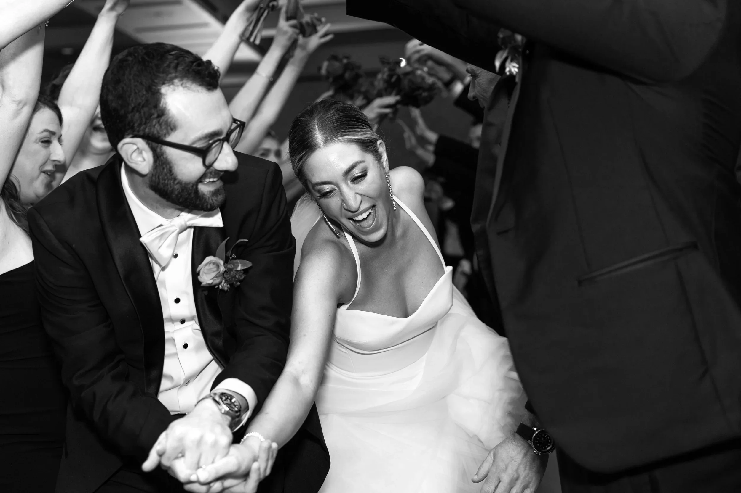Black and white wedding reception photo of bride and groom running through bridal party tunnel at Royal Park Hotel