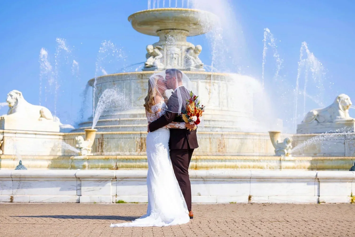 Bride and groom kissing under the veil at Belle Isle in Detroit, Michigan