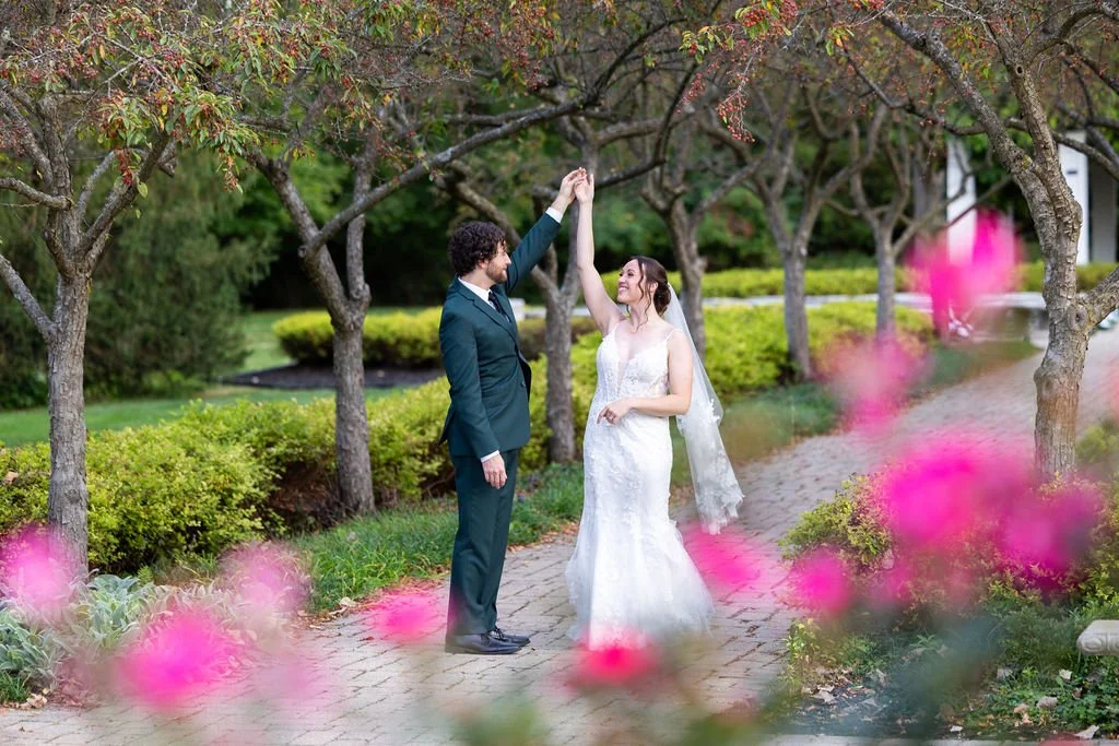 Groom dances with bride in the garden at Wellers Weddings