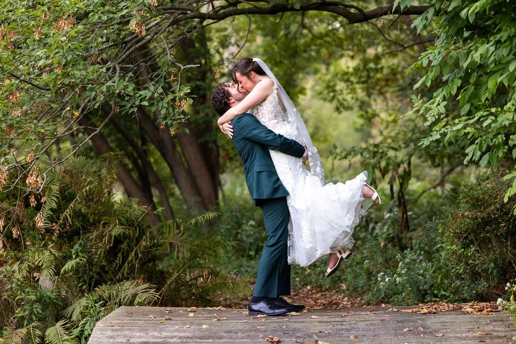 Groom holds bride and kisses her at Weller's Weddings in Saline, Michigan