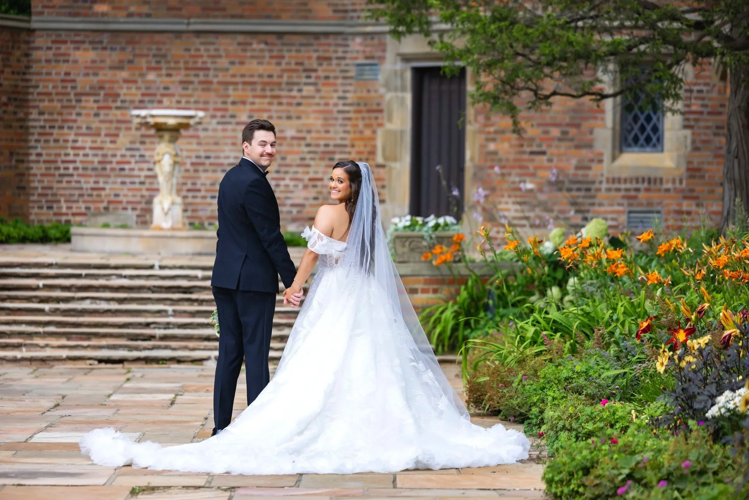 bride and groom walk away together at meadow brook hall in rochester, michigan