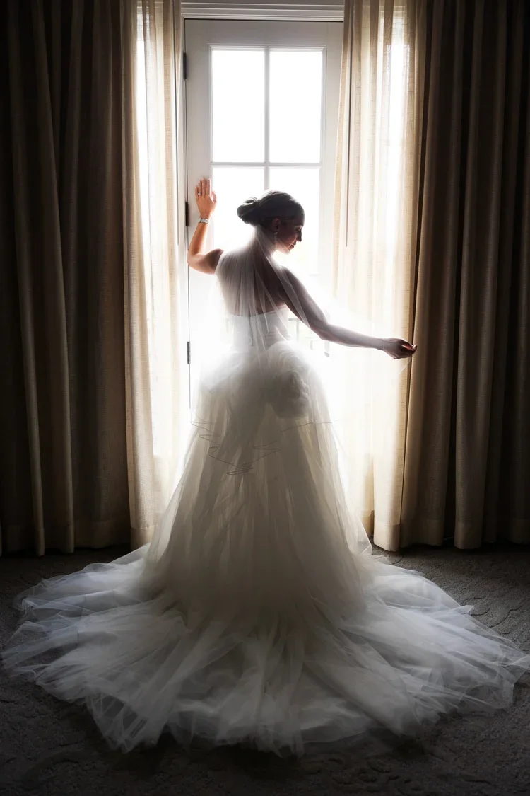 Bride posing in front of window at Royal Park Hotel in Rochester, Michigan