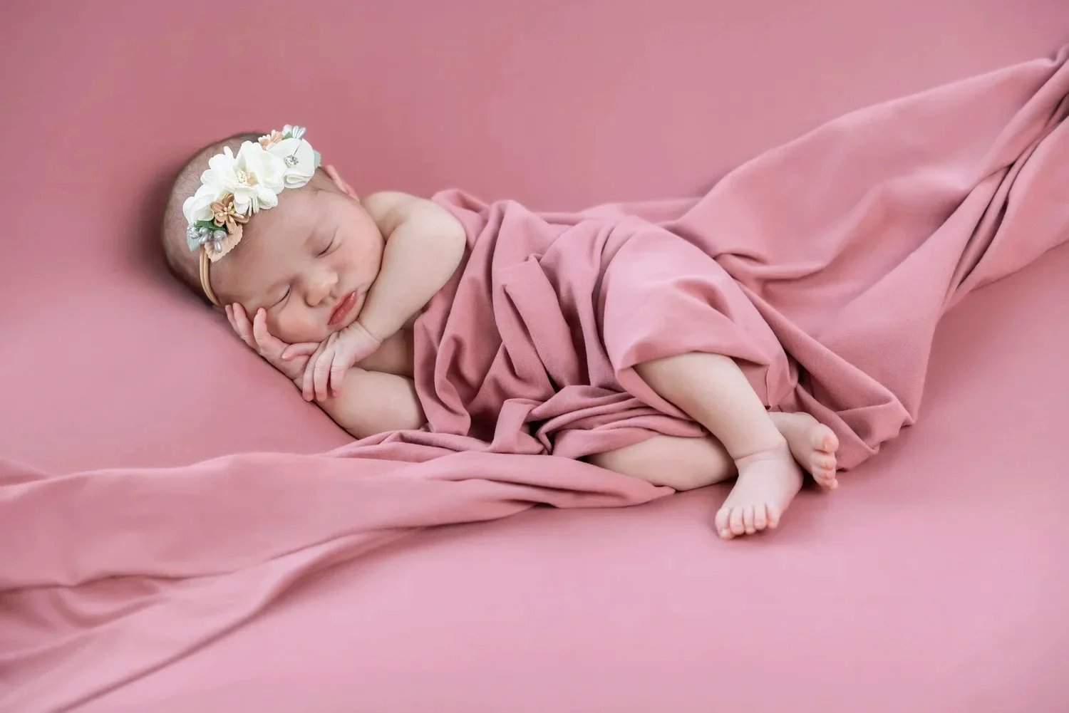 newborn baby in pink blankets in Fenton portrait studio