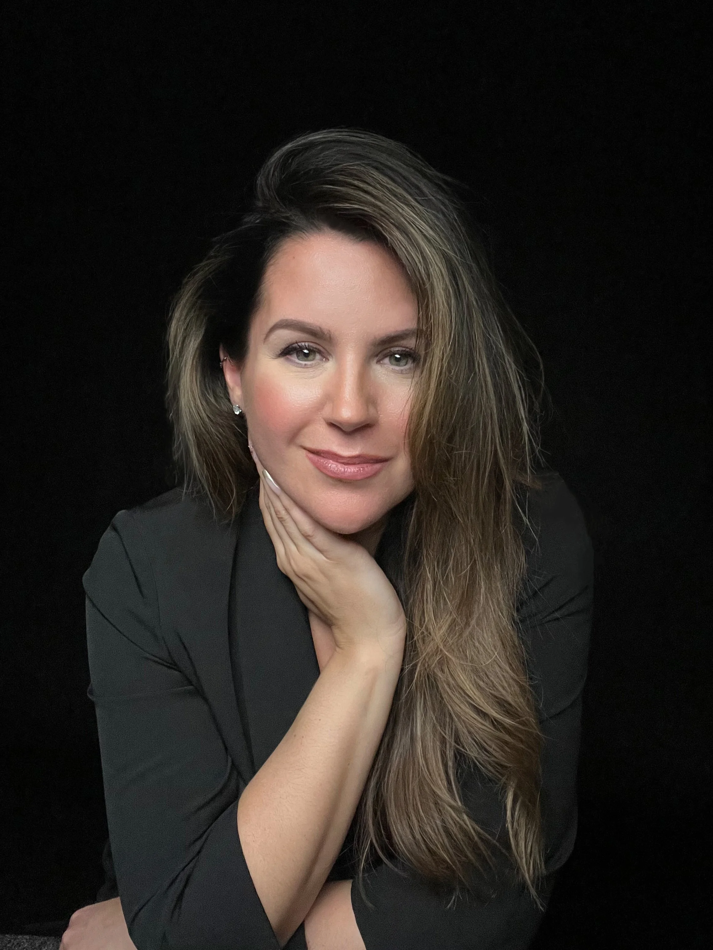 Studio portrait on black background of Lola Helka, owner and photographer of Lola Marie Photography