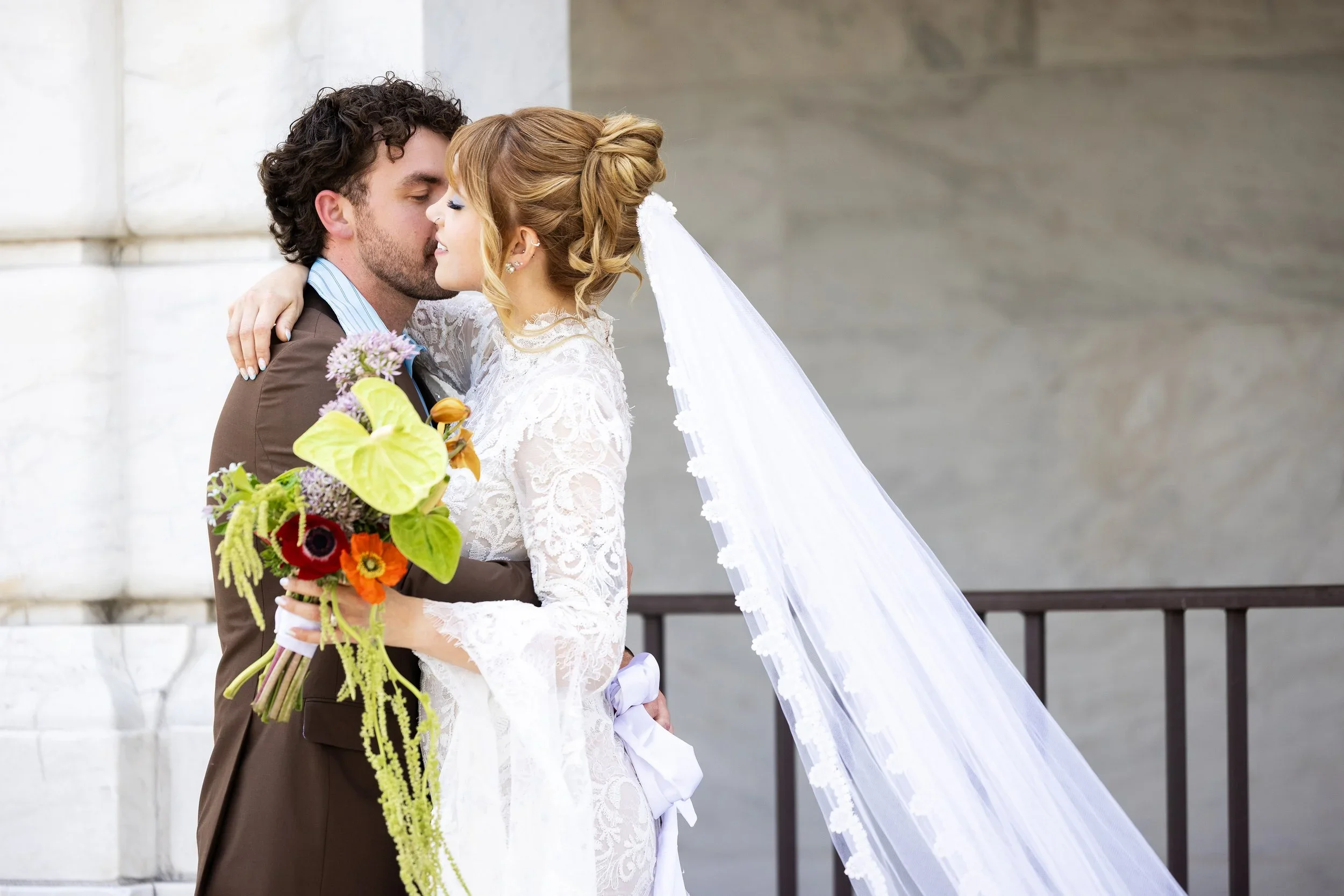 Bride and groom embracing on their wedding day outside the DIA in downtown Detroit, Michigan