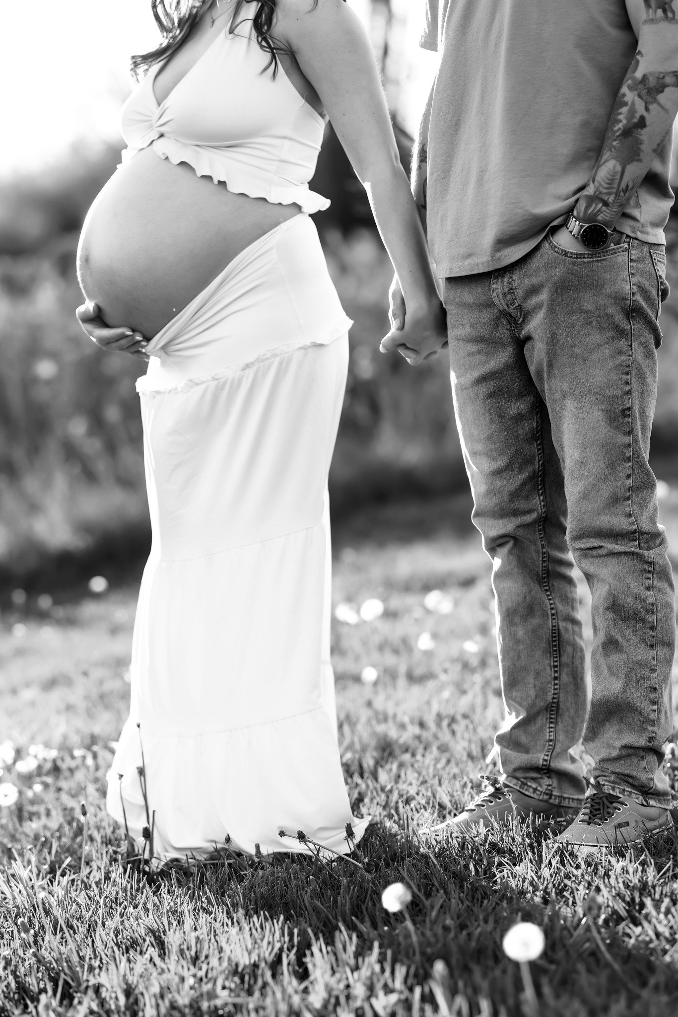 Expecting mother in flowing neutral gown at golden hour in Fenton, Michigan maternity session