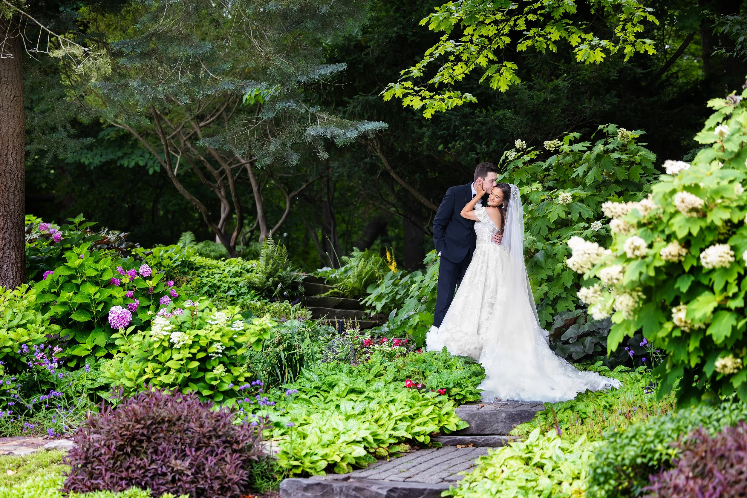 Bride and groom embracing in a garden at Meadow Brook Hall in Rochester, Michigan