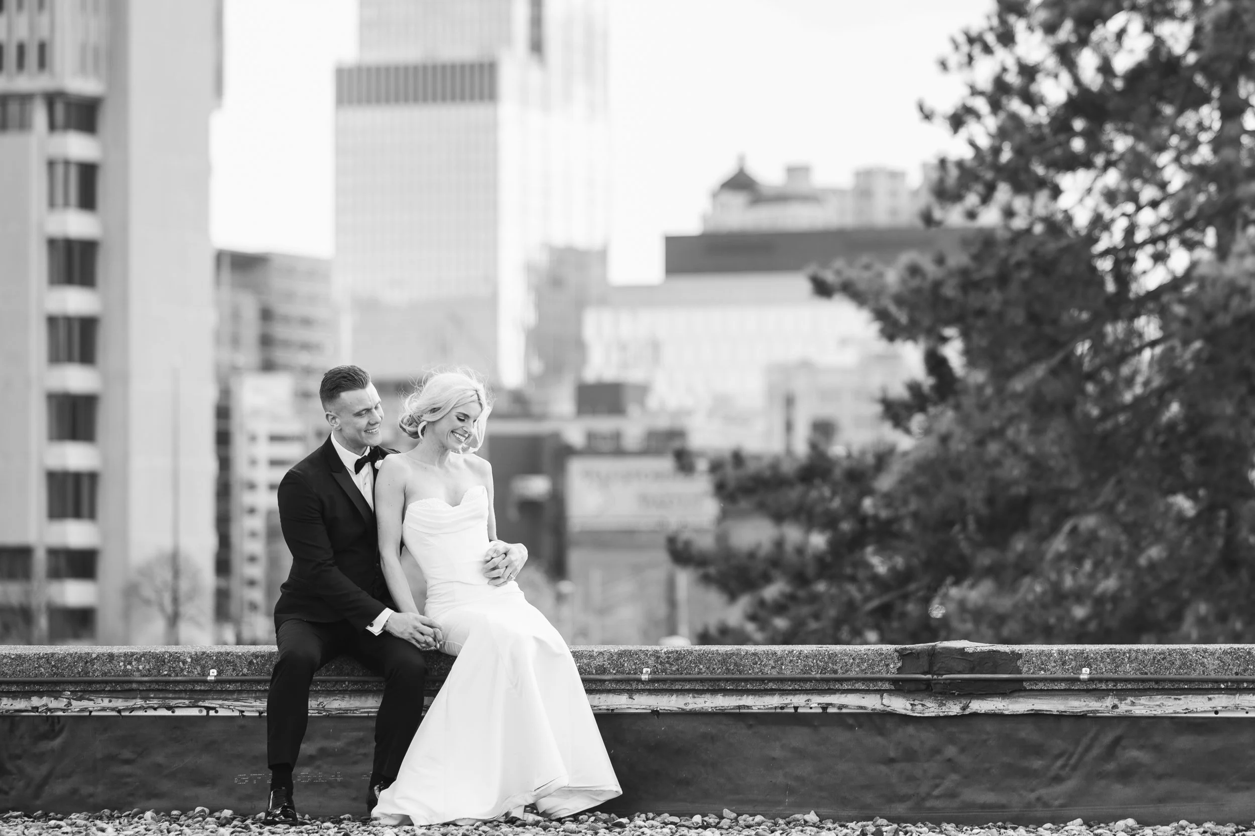 Bride and groom sitting on rooftop in downtown Detroit at The Whiskey Factory