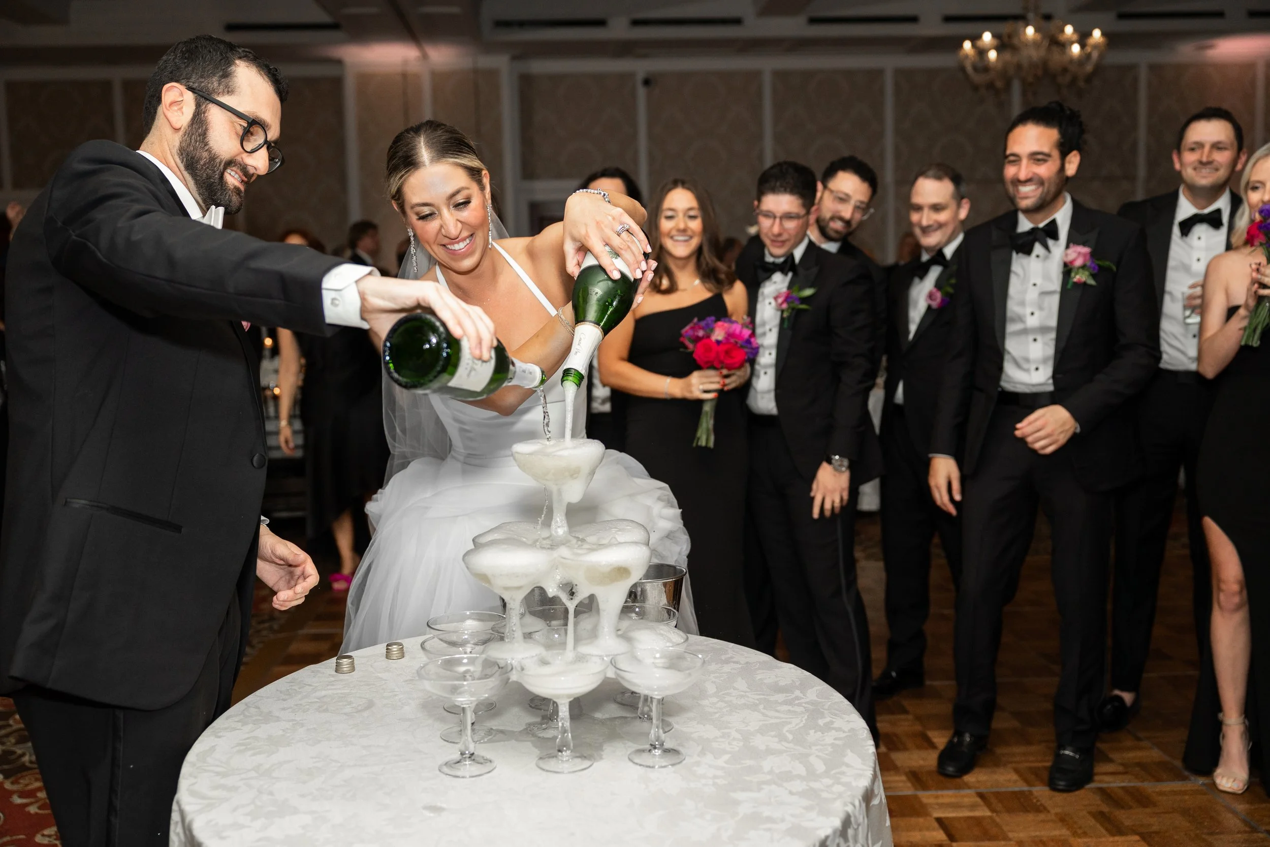 Bride and groom pouring champaign tower during wedding reception at Royal Park Hotel in Rochester, Michigan