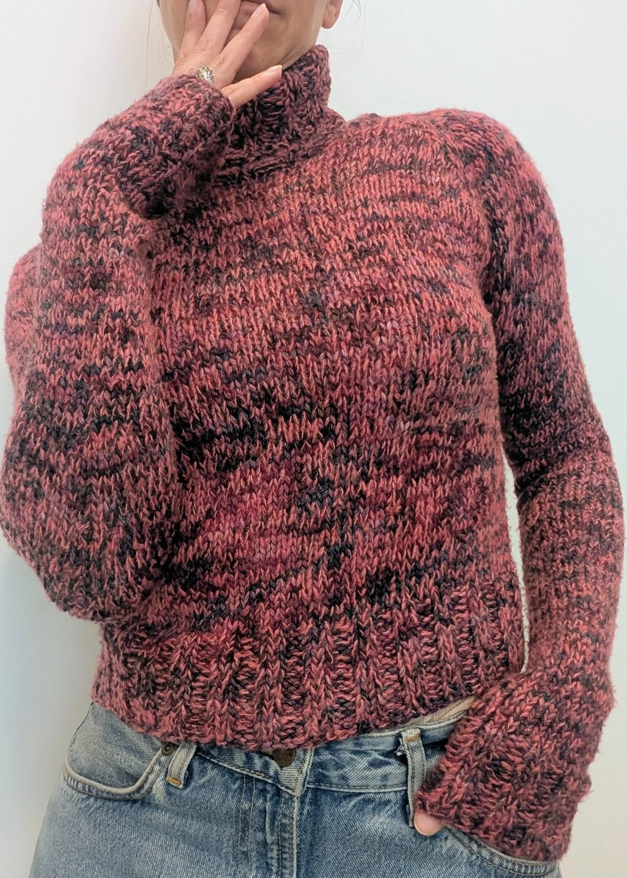 the torso of a woman is shown wearing a fitted pink and purple marled turtleneck sweater