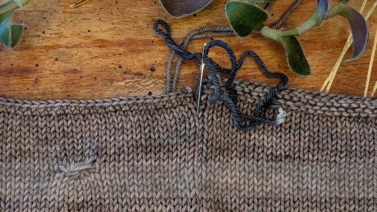 a completed seam is shown with the darning needle inserted into the top of the seam.