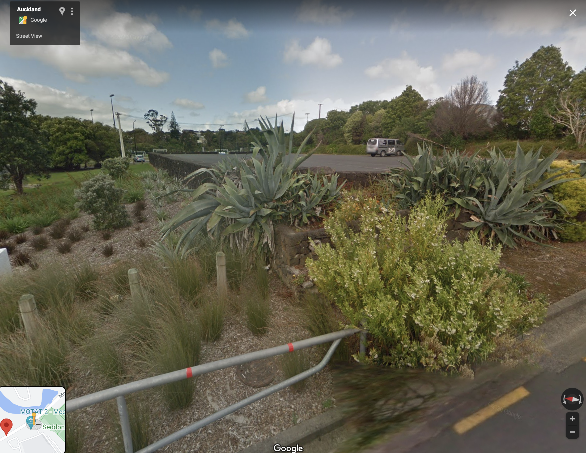 The location of the lower garden. Currently asphalt. Vision: grass, trees, reflection pool, waterfall from upper garden. Opportunity to increase the height of the stone wall.