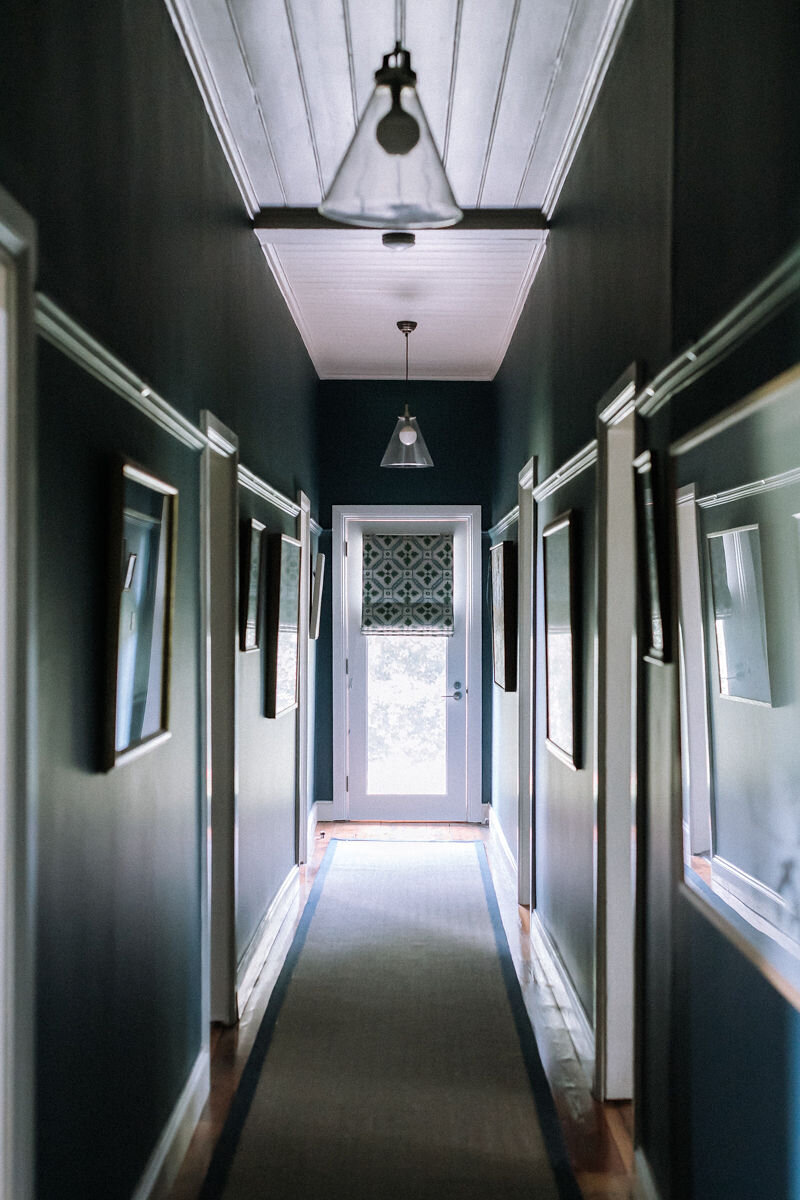  AFTER: The hallway is now a stunning dark green which has further defined the space, making the hallway feel grand and magnificent, not just a place to pass through. The addition of picture rails allows the clients artwork to hang like a gallery in 