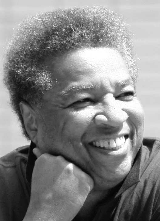 Black and white photo of composer Alvin Singleton, resting their chin on their hand.