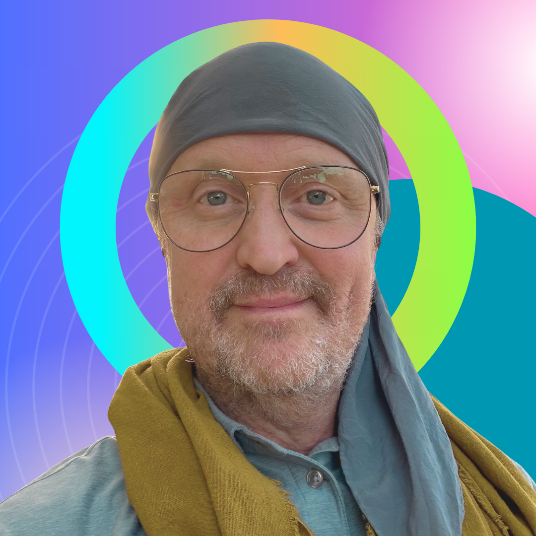 A man wearing glasses, a gray headscarf, and a mustard-colored jacket, with a colorful digital background featuring overlapping circles and gradient patterns.