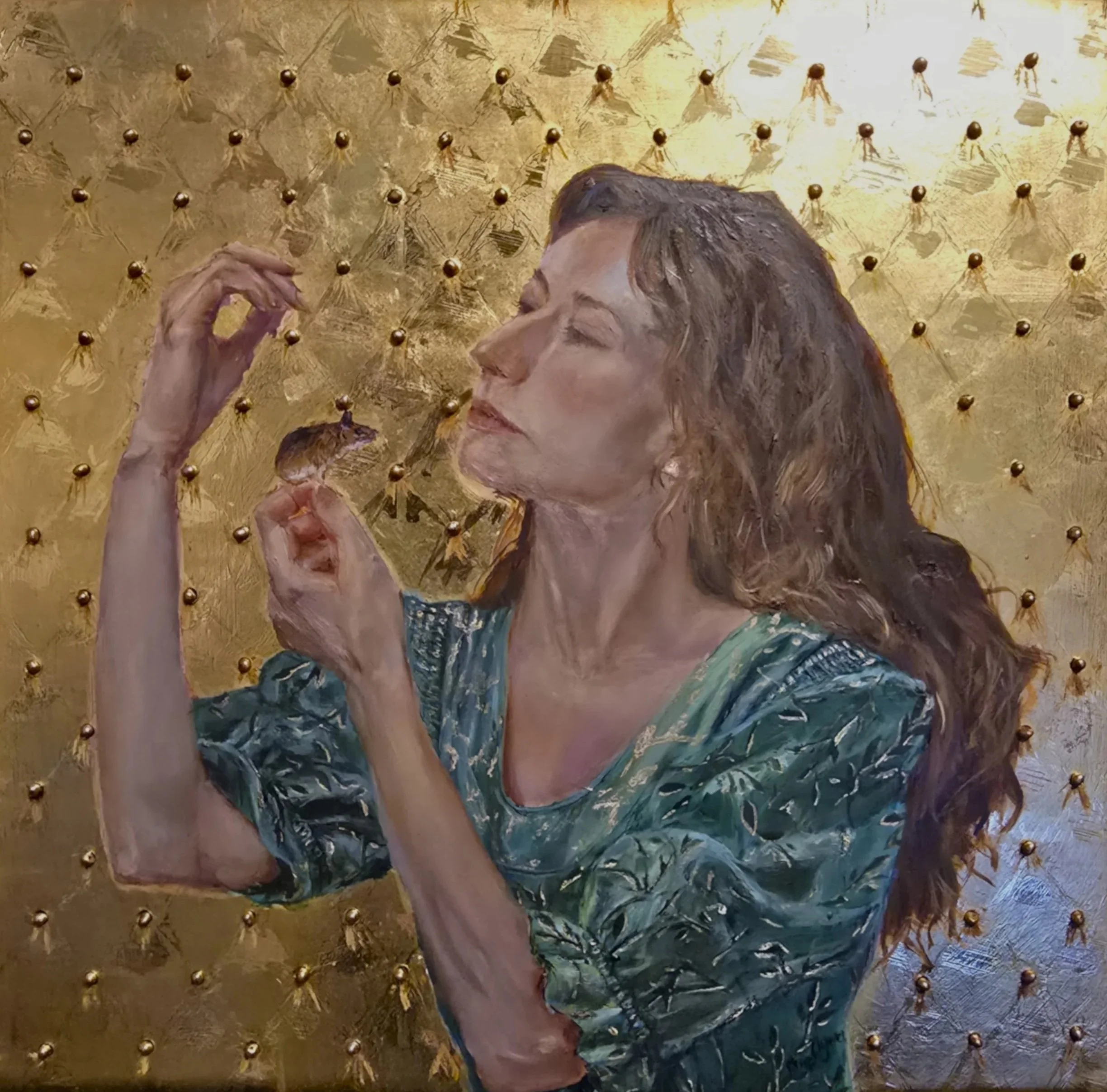 A woman with curly brown hair wearing a green patterned blouse, holding a small mouse near her face, against a gold textured background with small spherical embellishments.