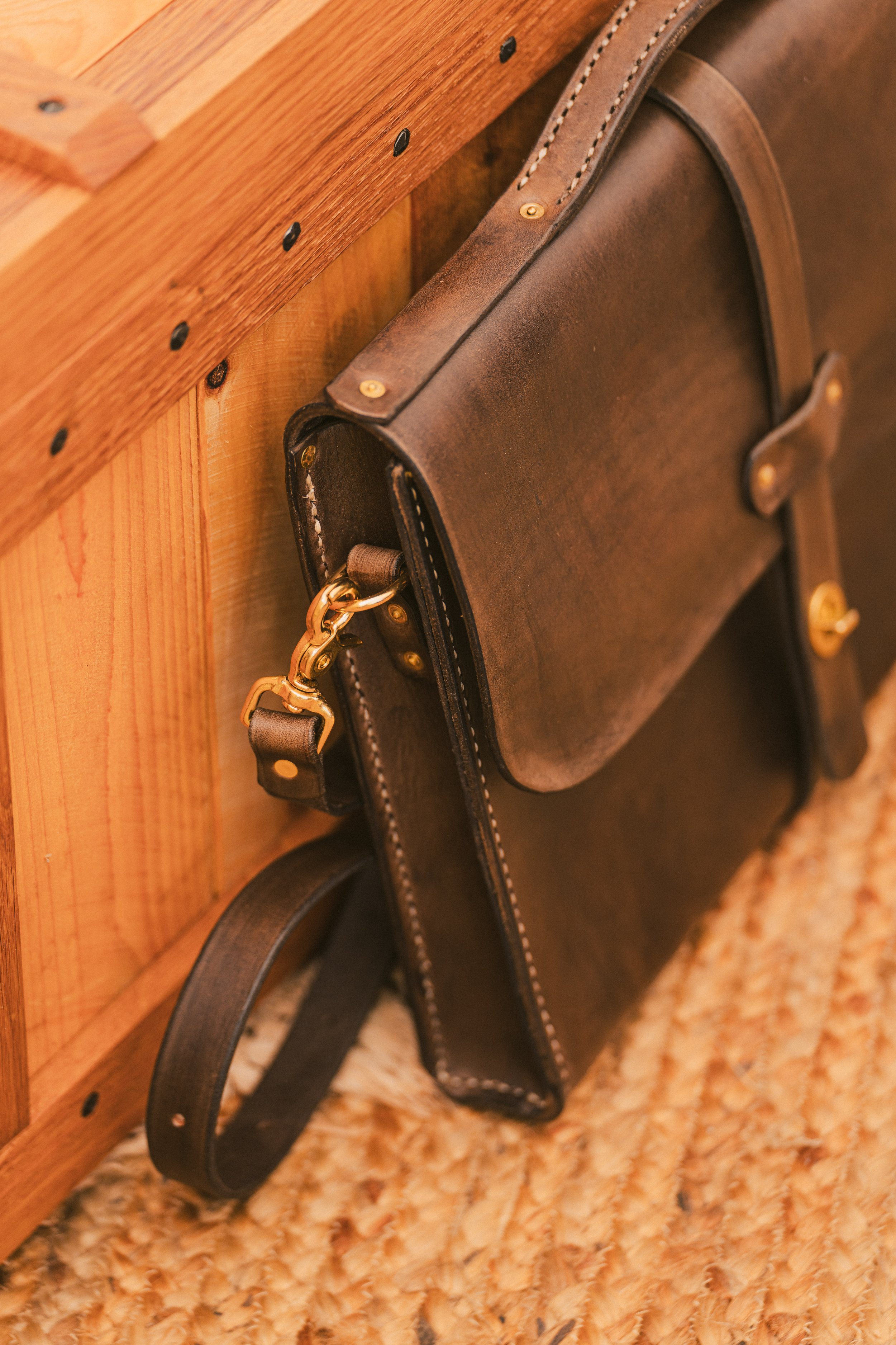 Side view of the Plane & Boring leather messenger bag showcasing its sleek profile and premium 8oz vegetable-tanned leather, built to develop a unique patina over time