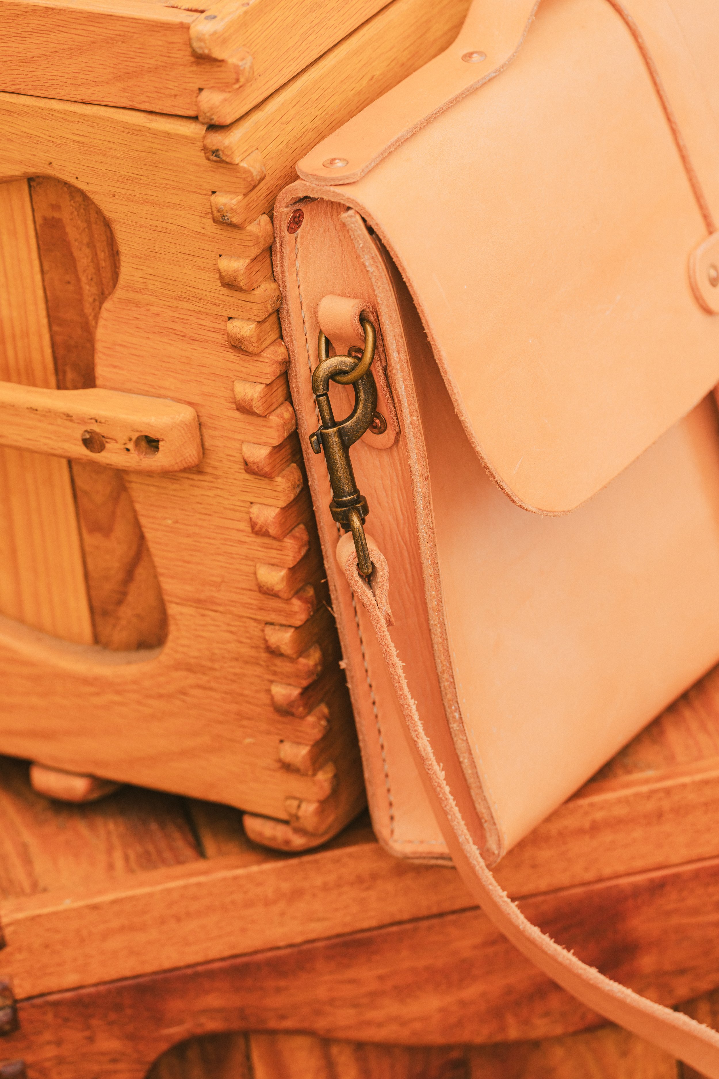 Close-Up of Natural Leather Messenger Bag "Close-up of the natural leather messenger bag, highlighting hand-burnished edges and unique patina that develops with use
