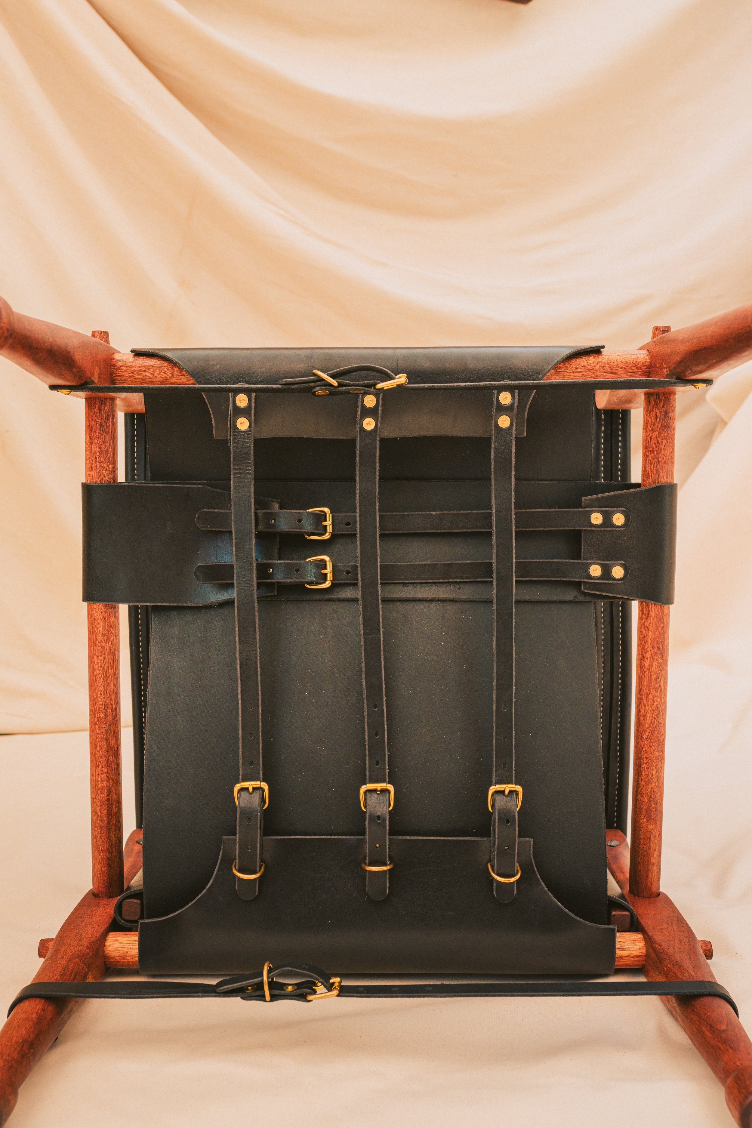 View of underside of black Roorkee chair with solid brass hardware