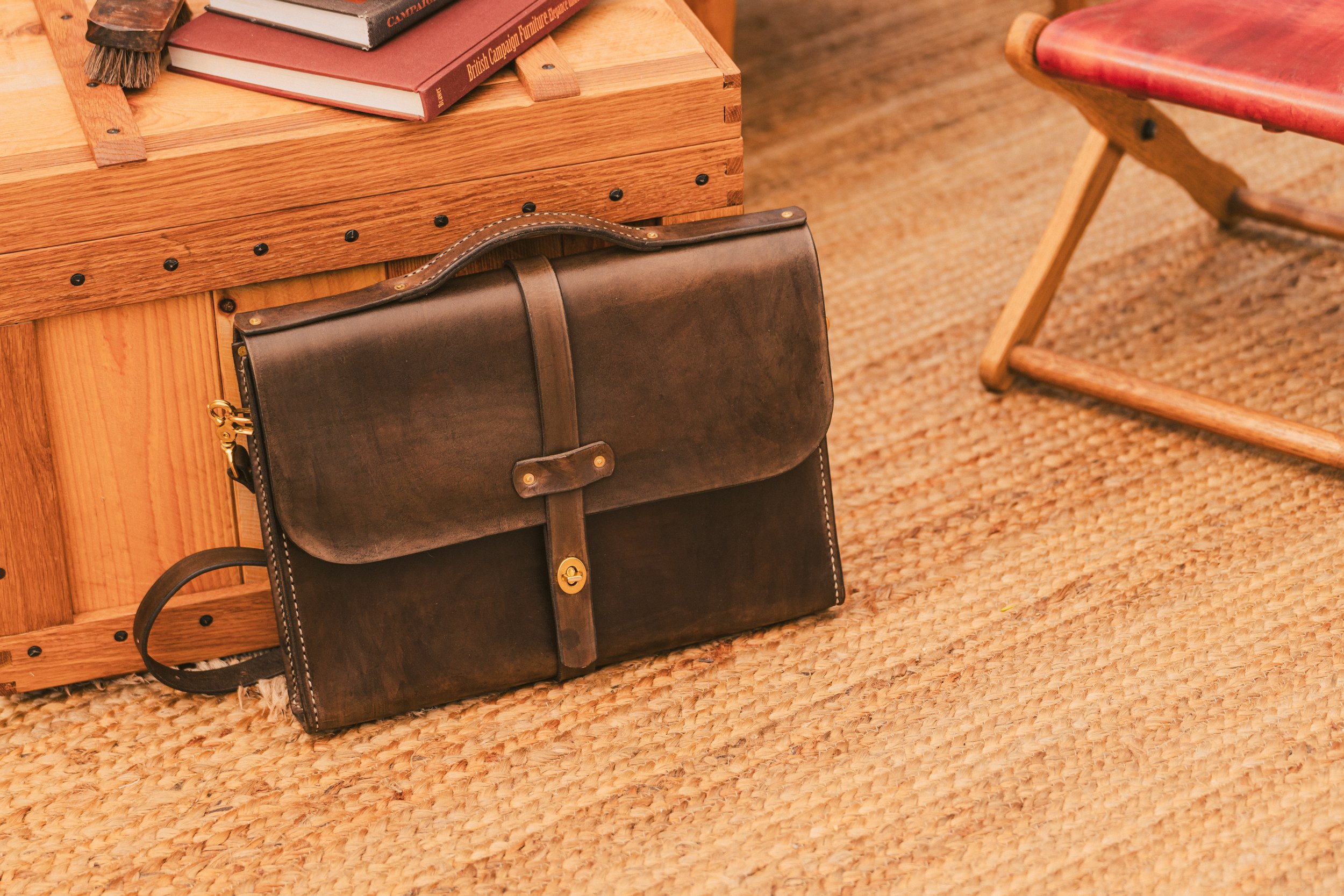 A handcrafted full-grain leather messenger bag featuring a classic design, solid brass hardware, and a convenient turn-lock closure. Ideal for carrying laptops and daily essentials