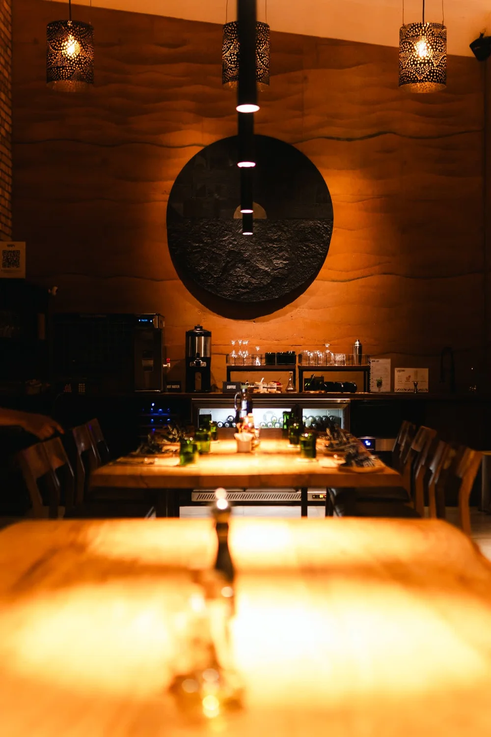 The dining room at night, lit by pendant lamps