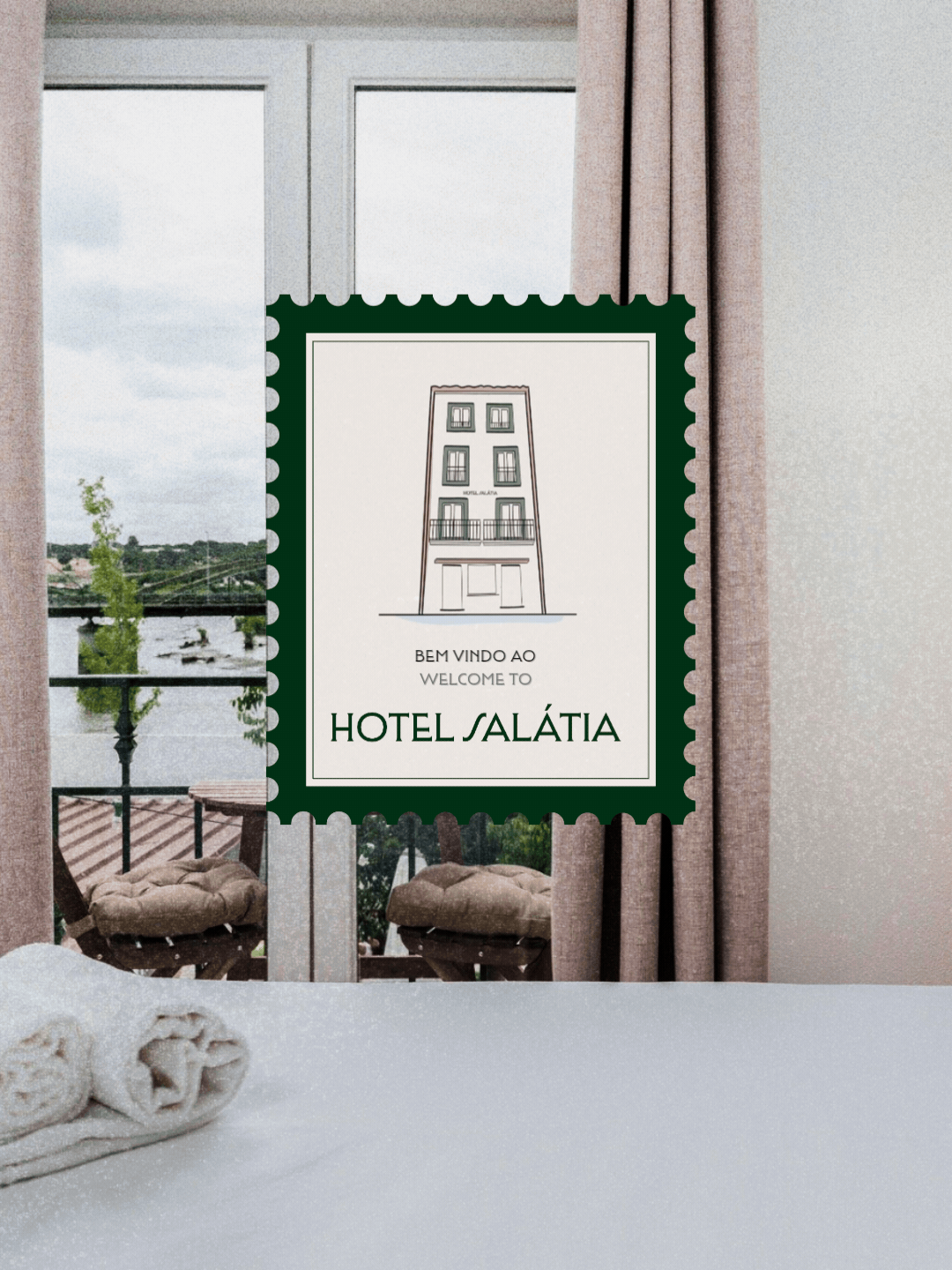 Branding for Hotel Salátia. A welcome sign for Hotel Salátia hanging on a window with balcony and river view in the background. The sign features an illustration of the hotel building and includes text in Portuguese and English.