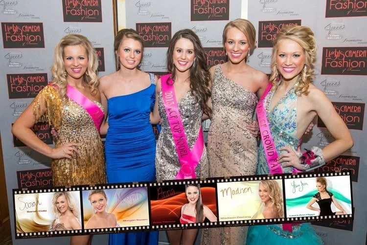 Five young women in evening gowns posing for a photo at a beauty pageant event. They are smiling and standing in front of a backdrop with event branding.