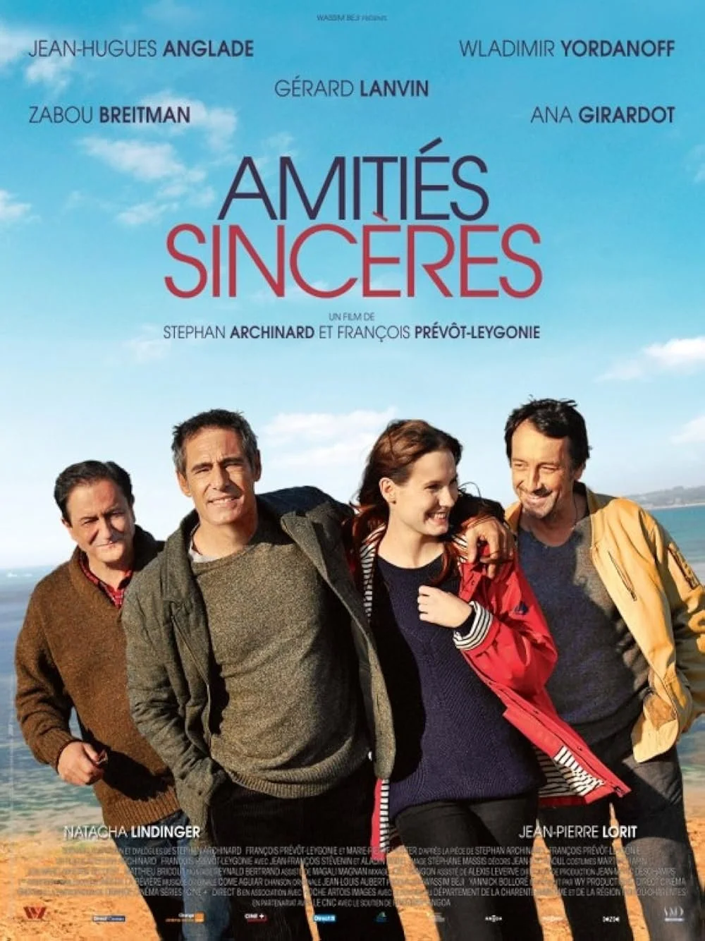 Movie poster for 'Amitiés Sincères' featuring four smiling people walking outdoors near water against a blue sky with clouds. Text includes the film's title and cast names.